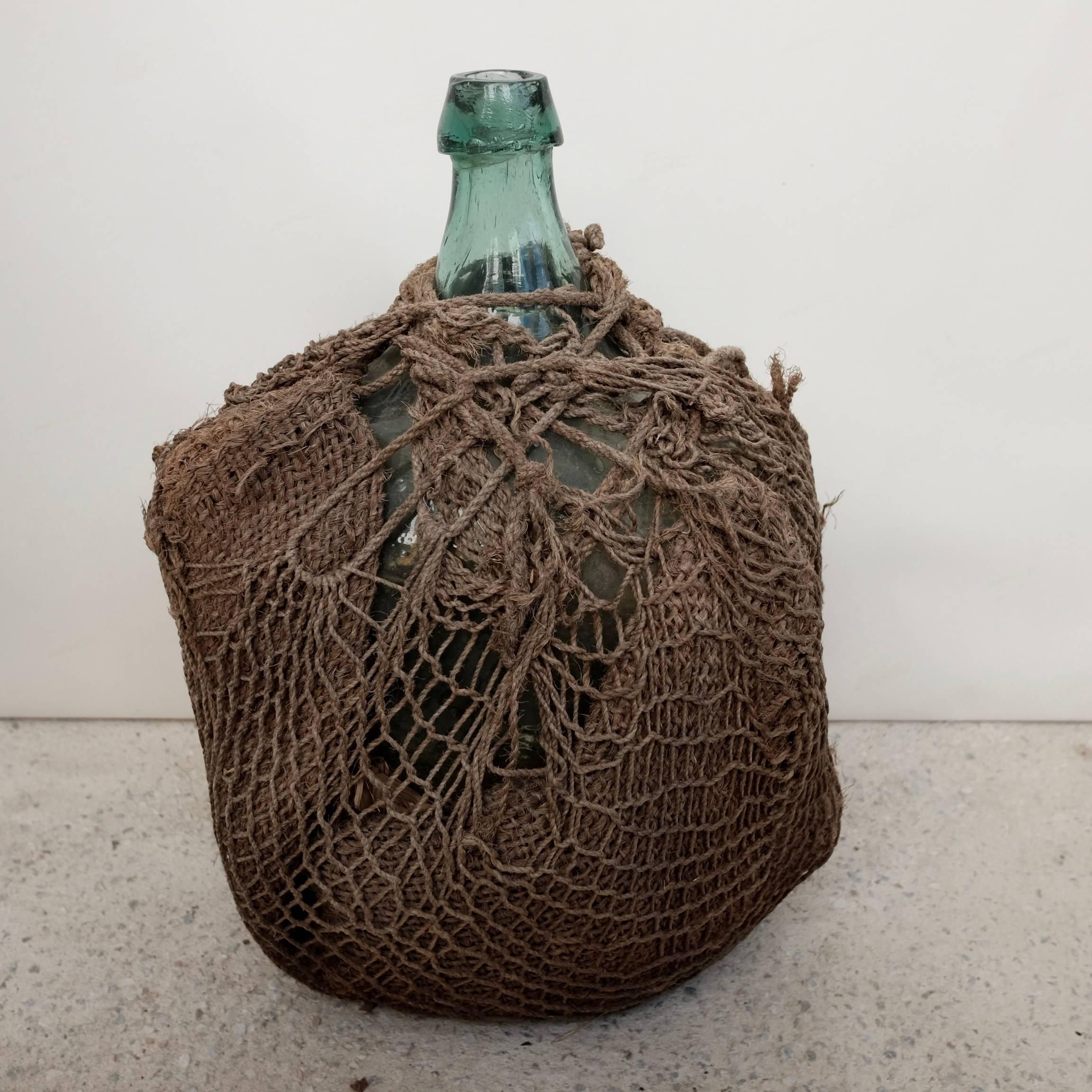 Vintage Mezcal jug with original net rope fabric used for protecting the bottle. From southern Oaxaca, Mexico. This vessel is one of a kind.
