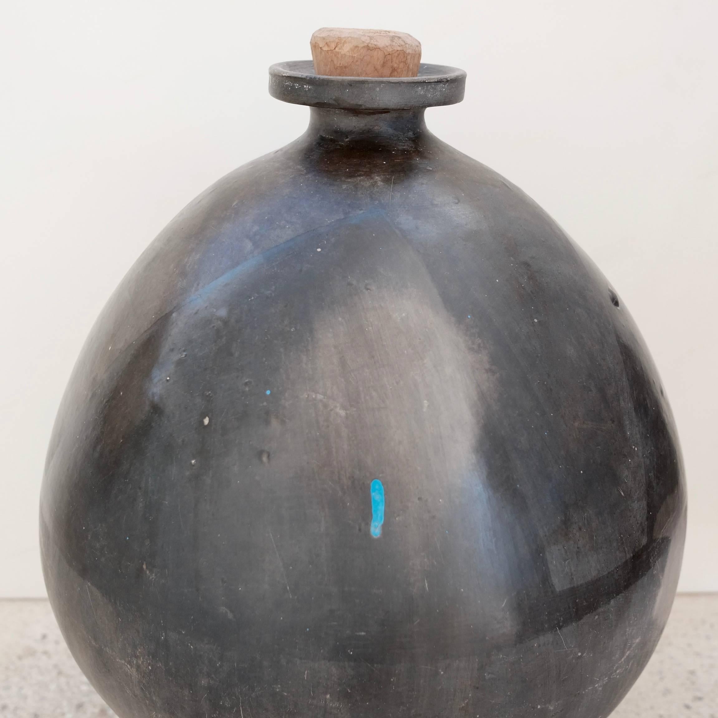 1957 lightly engraved, ceramic black clay pot or jug from San Bartolo Coyotepec, Oaxaca. Used in the 1950s, 1960s and 1970s for transporting local mezcal by way of donkey from village to village by tying ixtle rope from the vessel's neck. This style