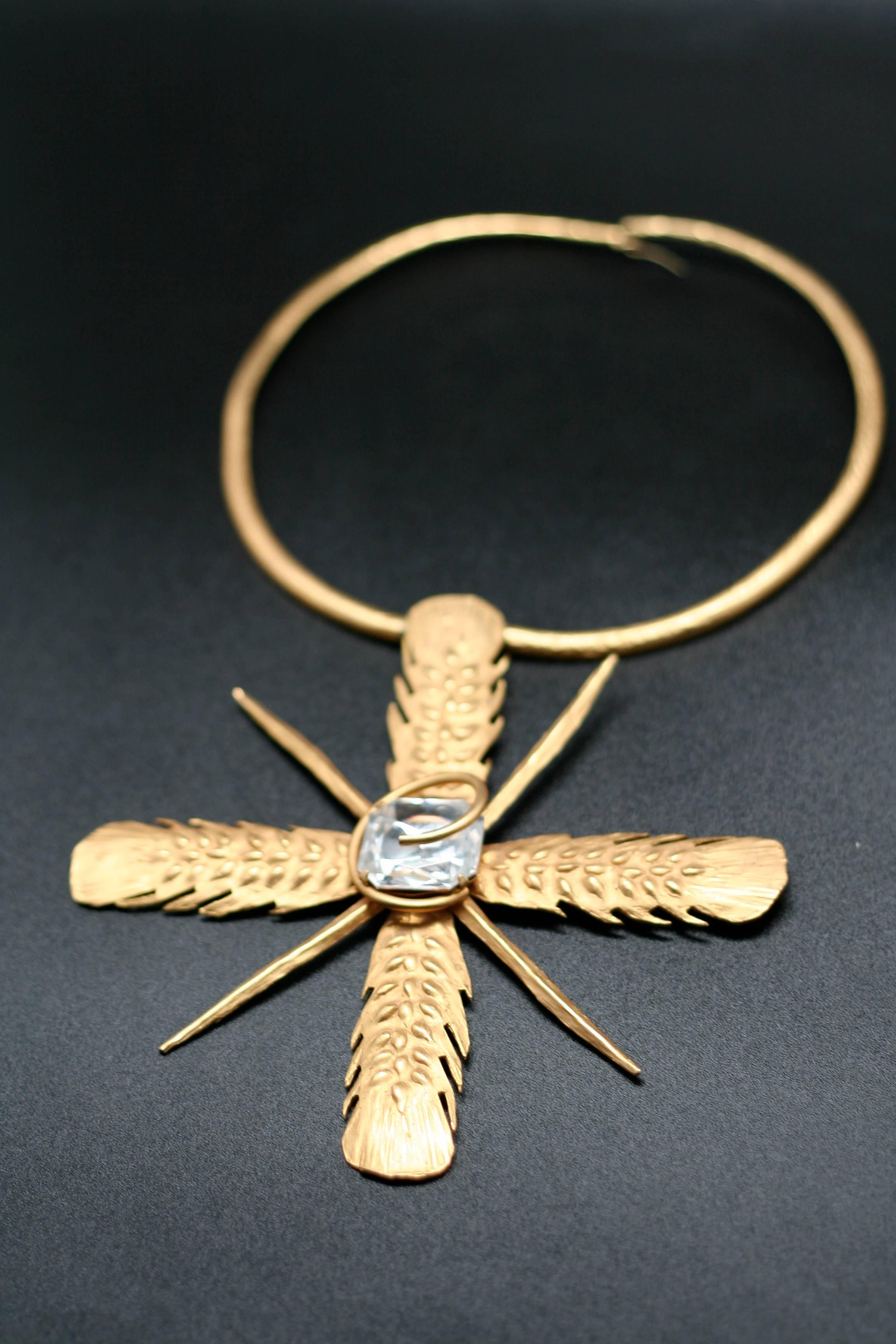 Yves Saint Laurent Rive Gauche, articulated necklace with a solar pendant and ear of wheat pattern enhanced with a crystal.
Signed.