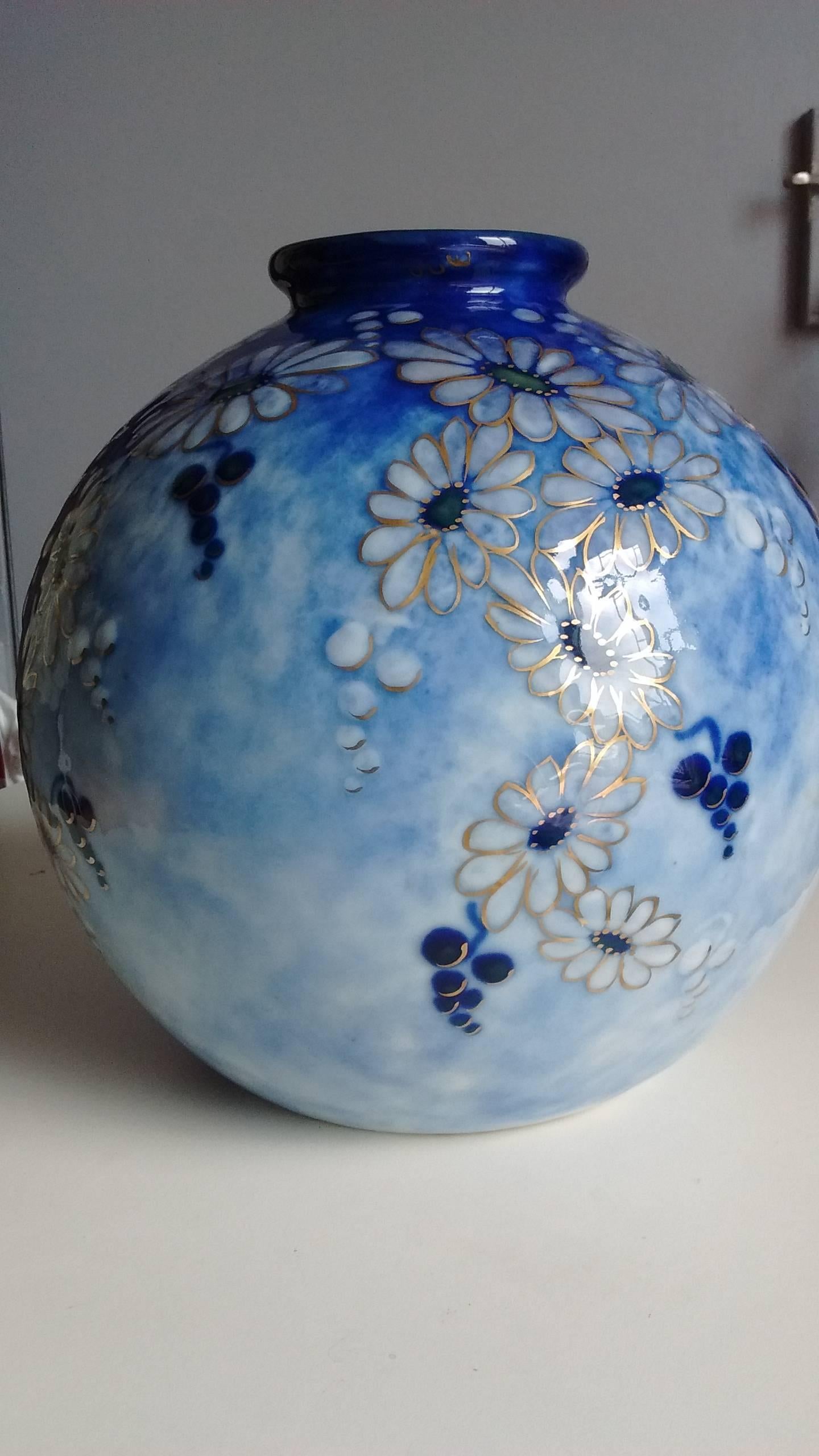 Porcelain vase with spherical body and hemmed neck. Decorative stylized flowers with a green heart slightly raised on a blue enamelled background marbled with shades of dark to light, contours enhanced with gold.
Signed Tharaud Limoges France, Made