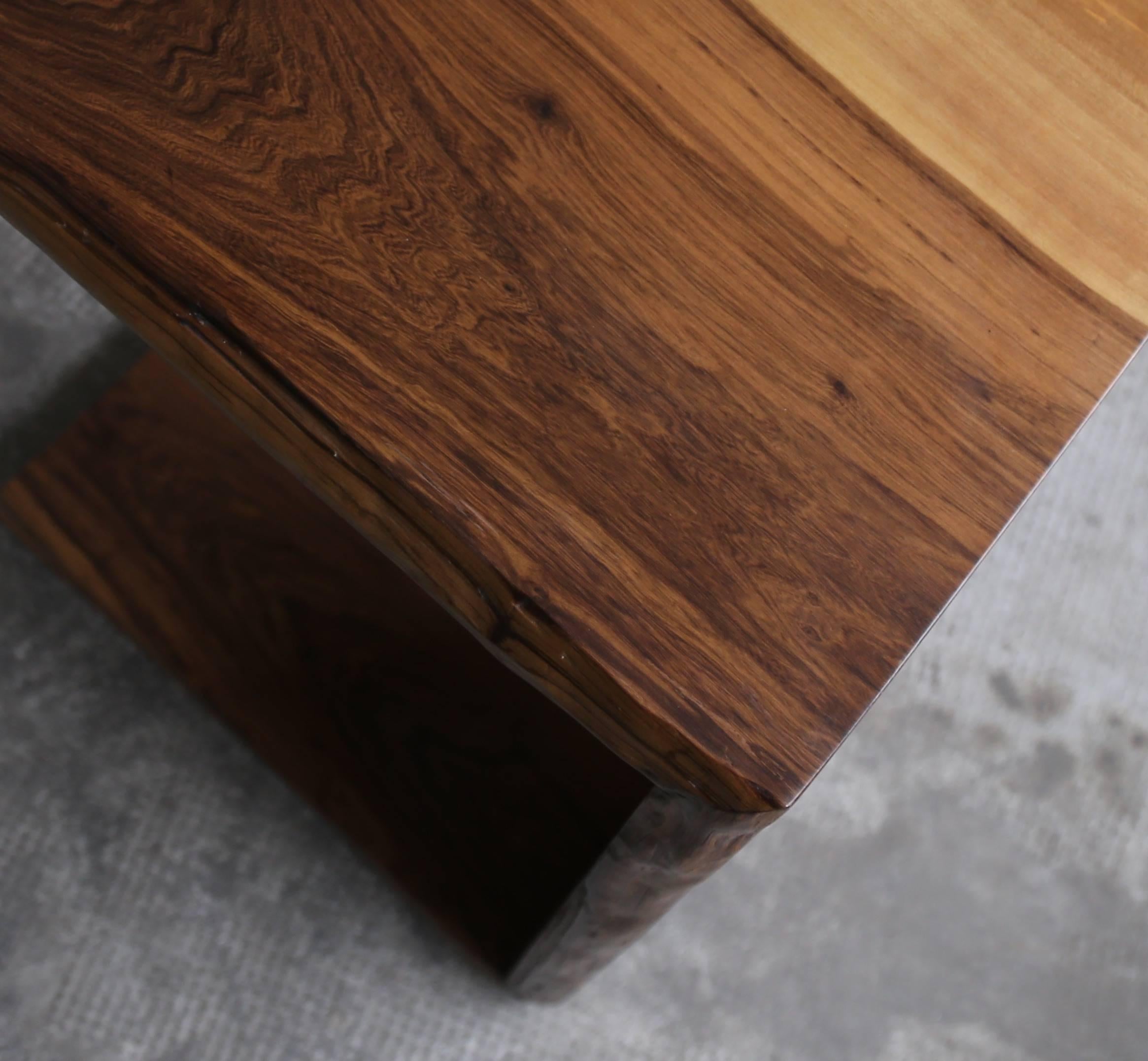 The Carlo Table is a cantilevered occasional table, designed to slide under a sofa or sitting area as necessary, and fashioned from slabs of Argentine Rosewood. Shown here in a natural finish, it is customizable to your desired dimensions.
