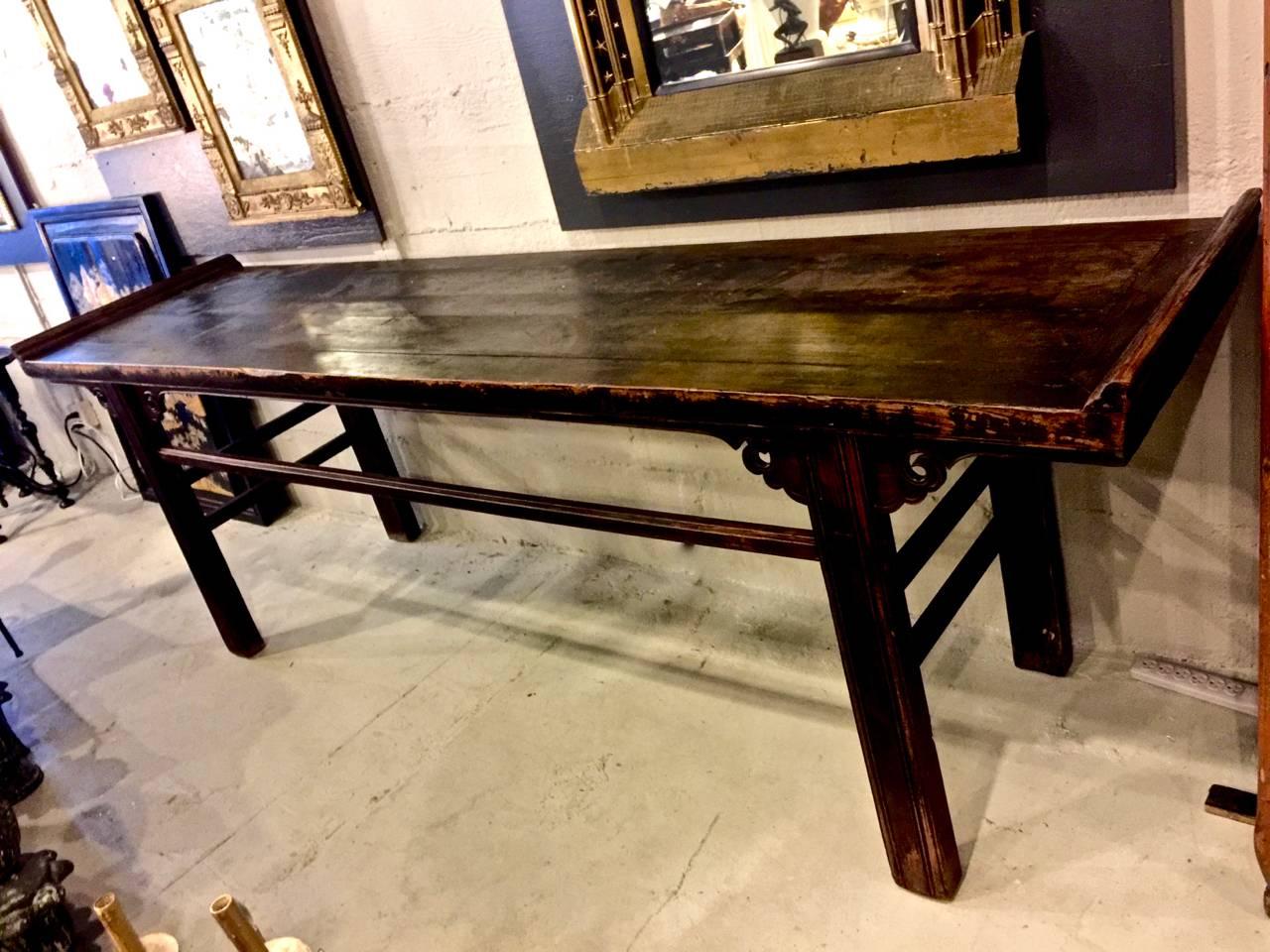 This is a long Chinese mid-19th century altar table in brown lacquered solid elmwood. The table has acquired a deep natural patina over its nearly two hundred years of use. This table would make a wonderful kitchen island work space or counter.