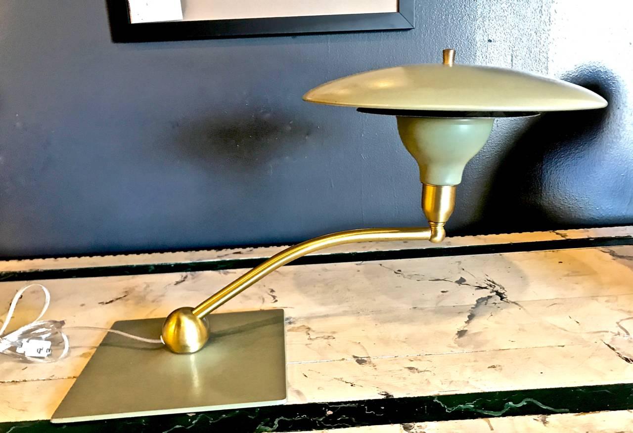 This is an excellent example of the iconic dazor flying saucer sight light desk Lamp. This lamp dates to circa 1960 and is in excellent original condition. The pivoting brushed brass light arm is in excellent condition as is the original minty-sage