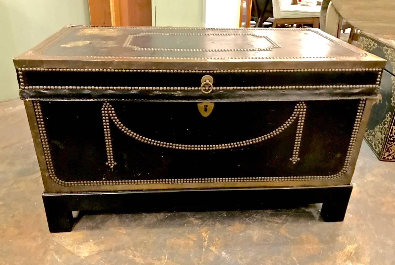 This is a large English Regency (circa 1820-1830) campaign trunk/chest that is leather clad and detailed in brass nail heads. The original leather is in overall very good condition with one slit to the leather top as shown in photo. The camphor wood
