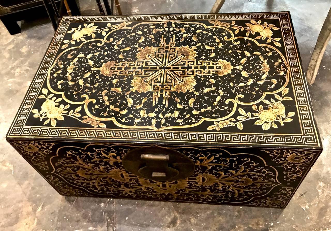 This is a large Chinese lacquered and painted trunk or chest. The trunk dates to the 20th century and features intricate painted chinoiserie motifs. The generous size of the trunk makes it easily adaptable to a coffee table. Overall very good to