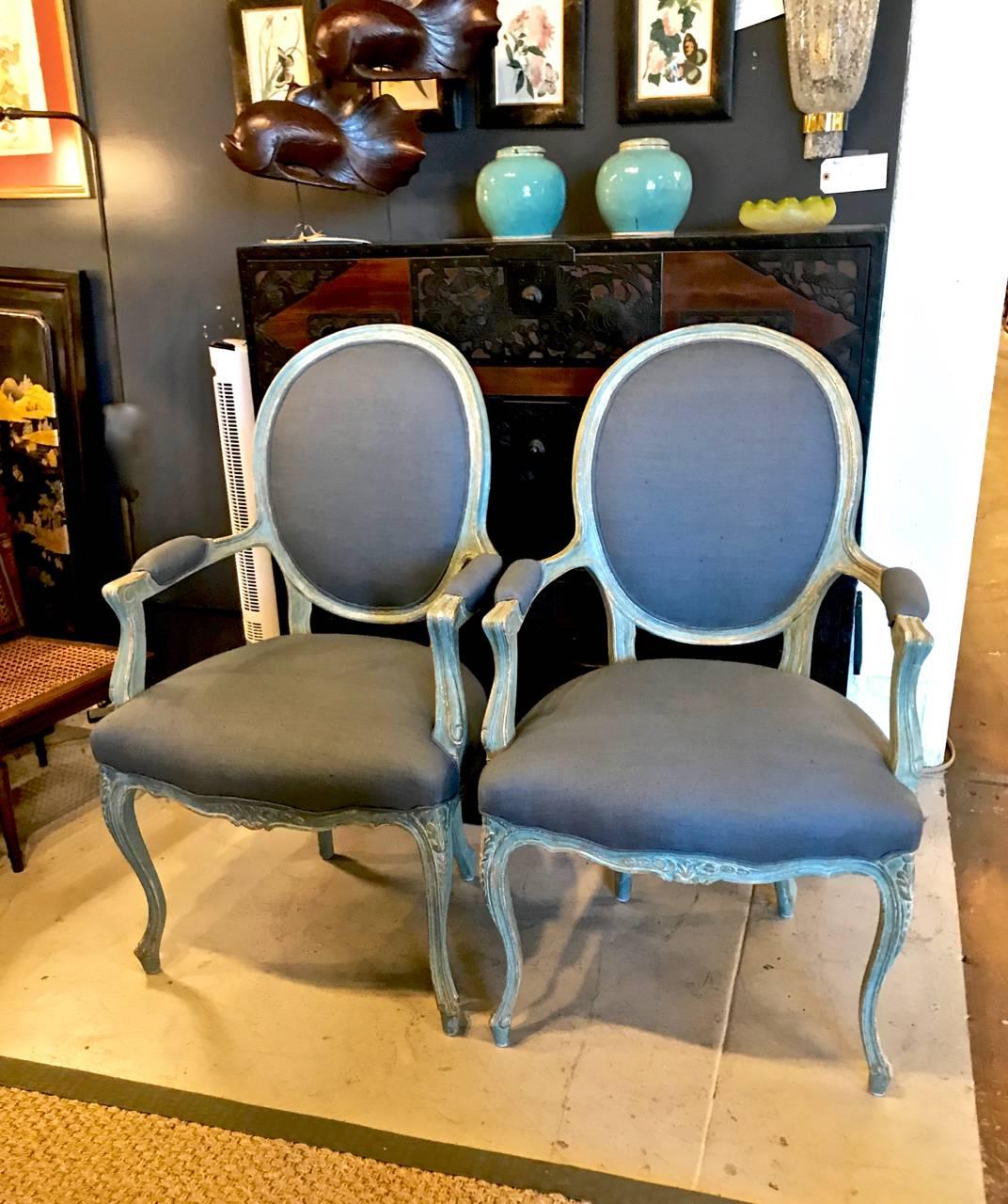 This is a stunning, generously proportioned, pair of painted open armchairs or fauteuils that date to the late 19th or early 20th century. The chairs retain their original painted sea foam green surface which has acquired a deep natural patina. The