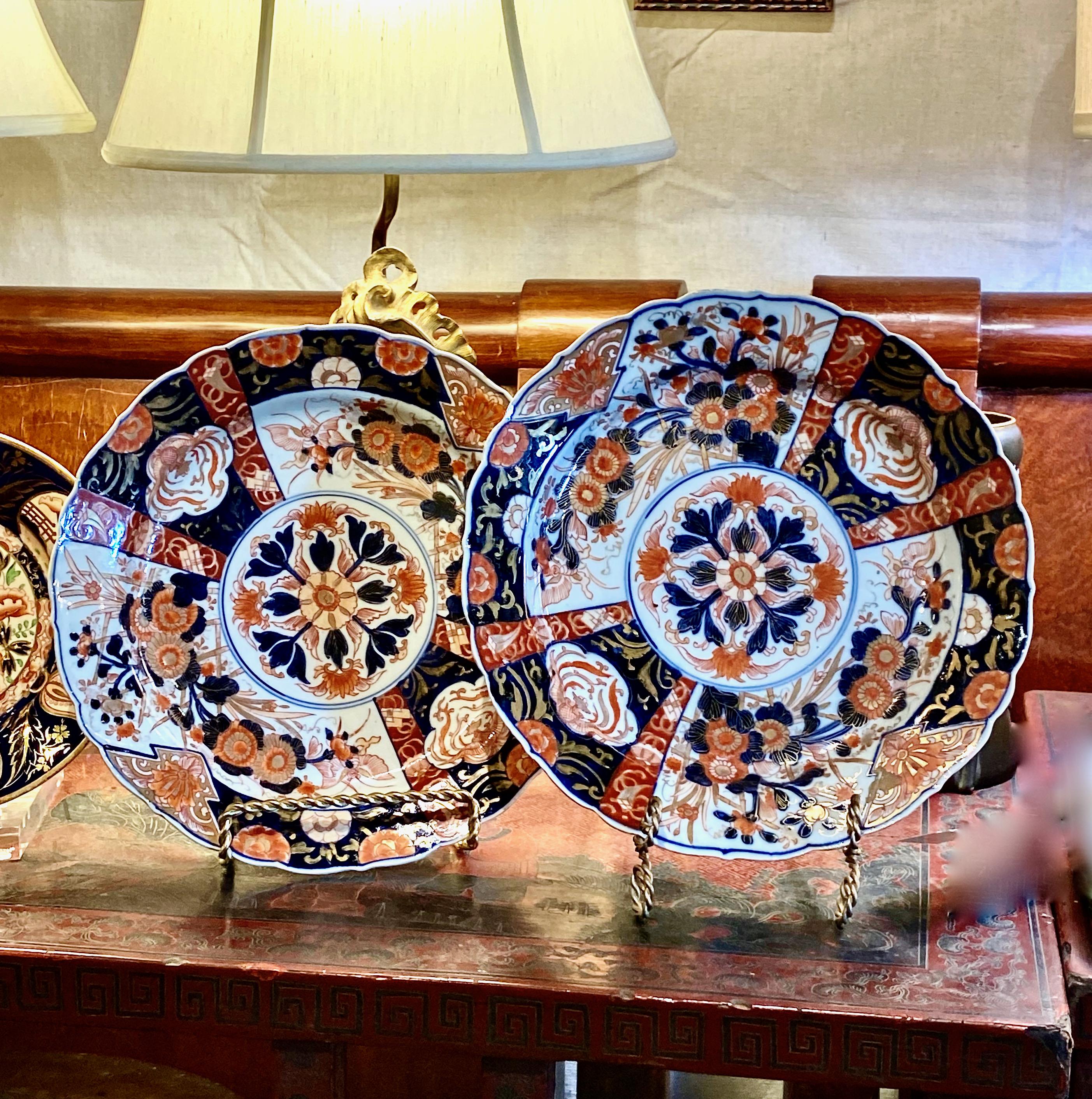 This is a gorgeous pair of Meiji period Imari chargers or large plates. The chargers date to the late 19th century and feature a center mandala with surround by large floral reserves and smaller abstract phoenix and lotus reserves in deep cobalt