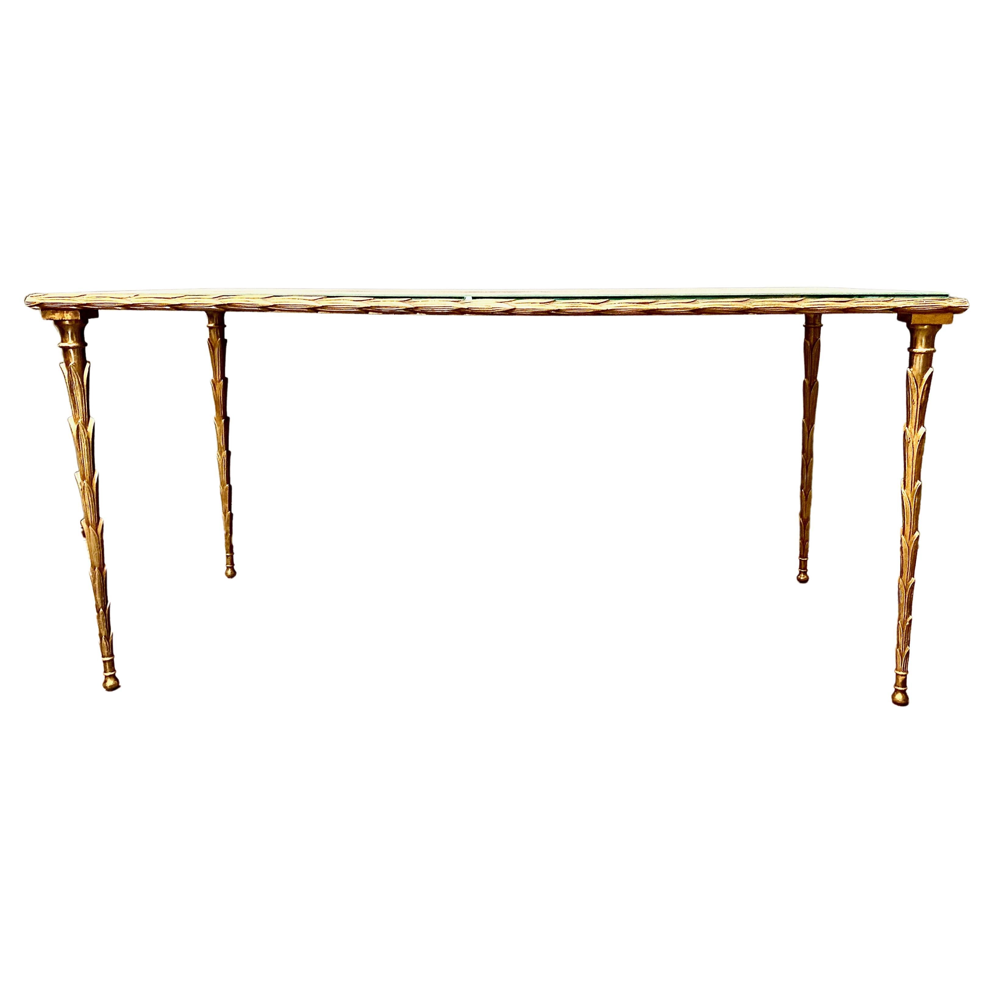 This is a superb example of a Maison Bagues coffee or cocktail table that dates to c. 1960-1969. The gilt bronze frame is cast in a palm tree form. The extending of the palm tree element to include the top surround is an additional indication of