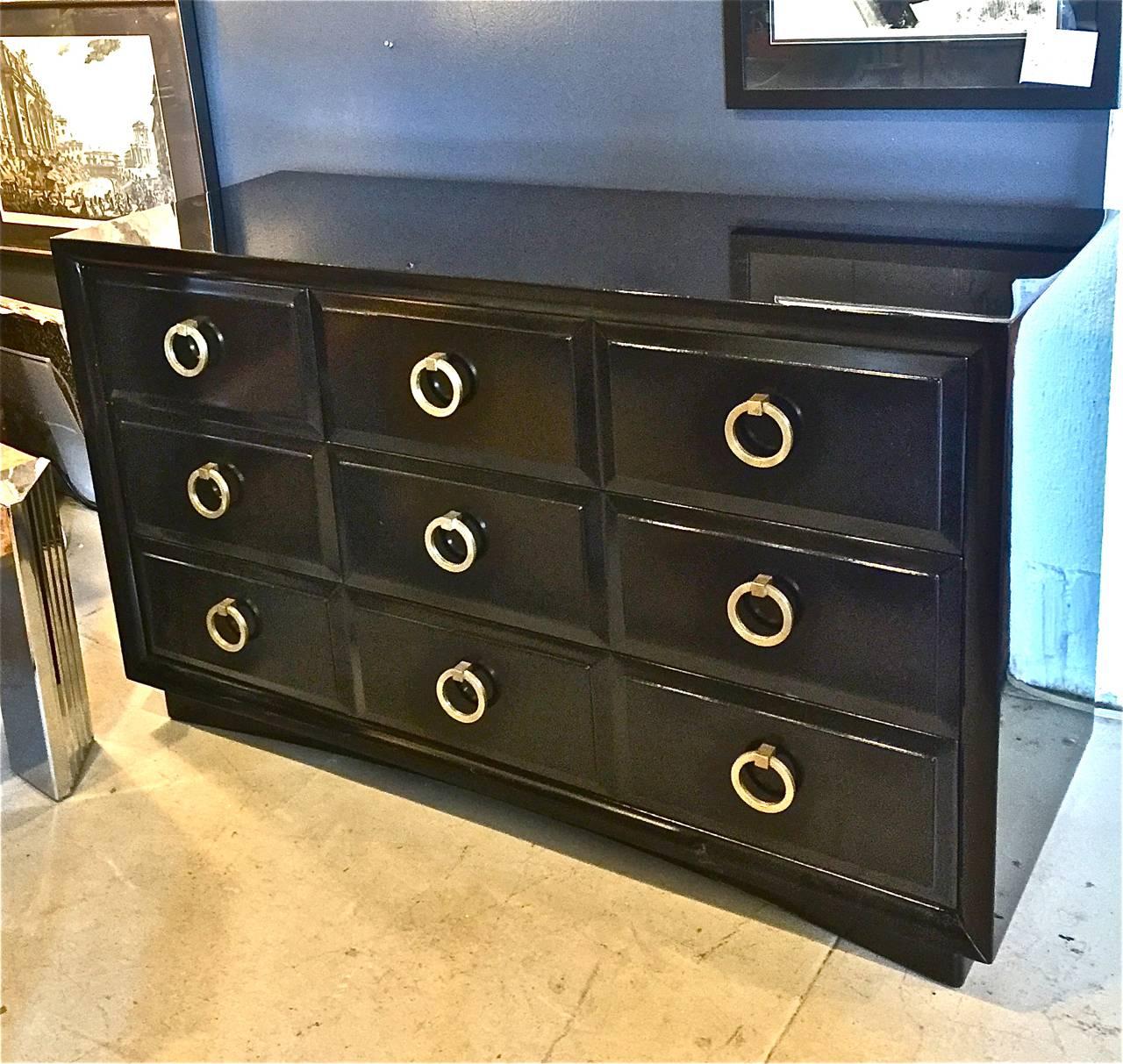 This is a beautiful Mid-Century Robsjohn-Gibbings by Widdicomb chest of drawers that dates to the late 1950s. The chest is newly lacquered in a black high gloss piano lacquer; it in mint condition and retains its original brass hardware.