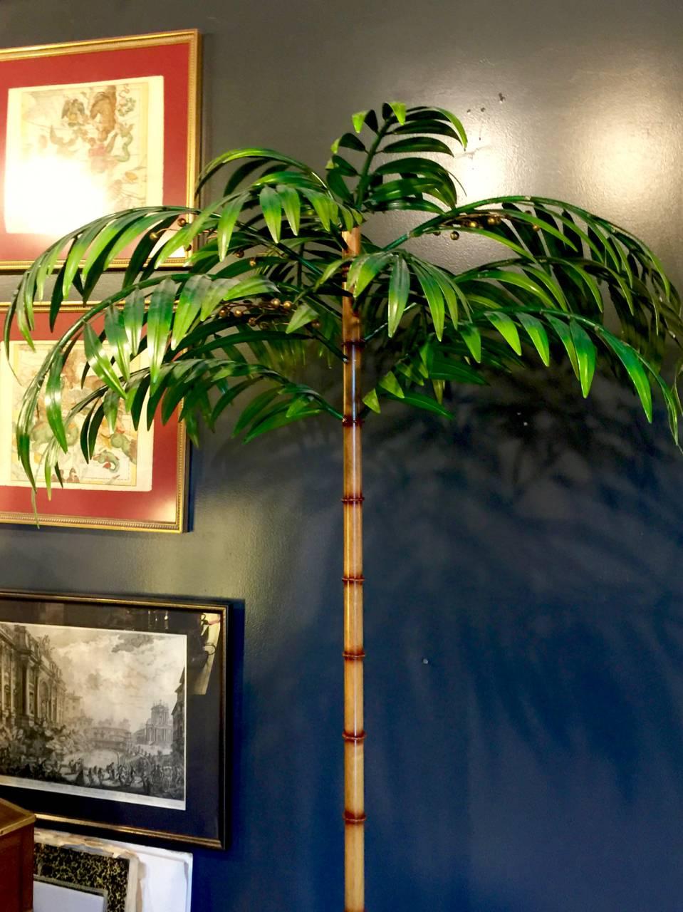 This is an exceptional and rare pair of Jansen-style tole palm trees in faux bamboo tole planters that dates to the 1960s. Measures: The 76 in. height combined with the fine detailing of the trees and the unusual faux bamboo planters make them