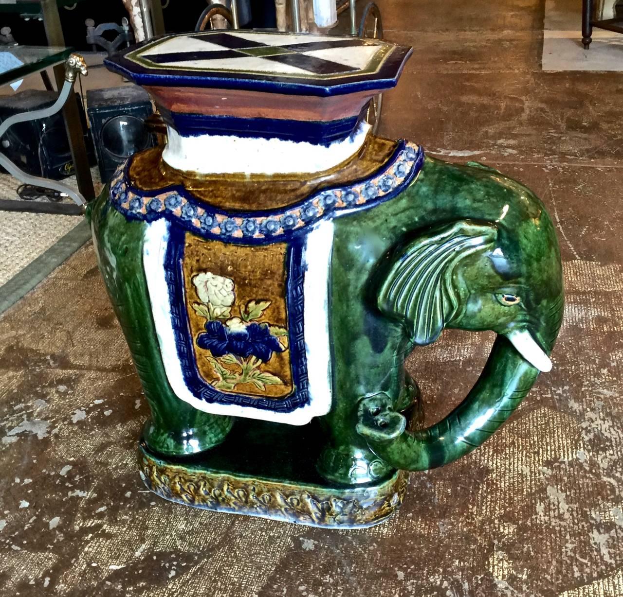 This is a great pair of circa 1950s glazed elephant stools or tables. The stools are well-detailed and in overall excellent condition, considering their age and use. The opposing elephants are glazed in a beautiful mottled green with deep blue