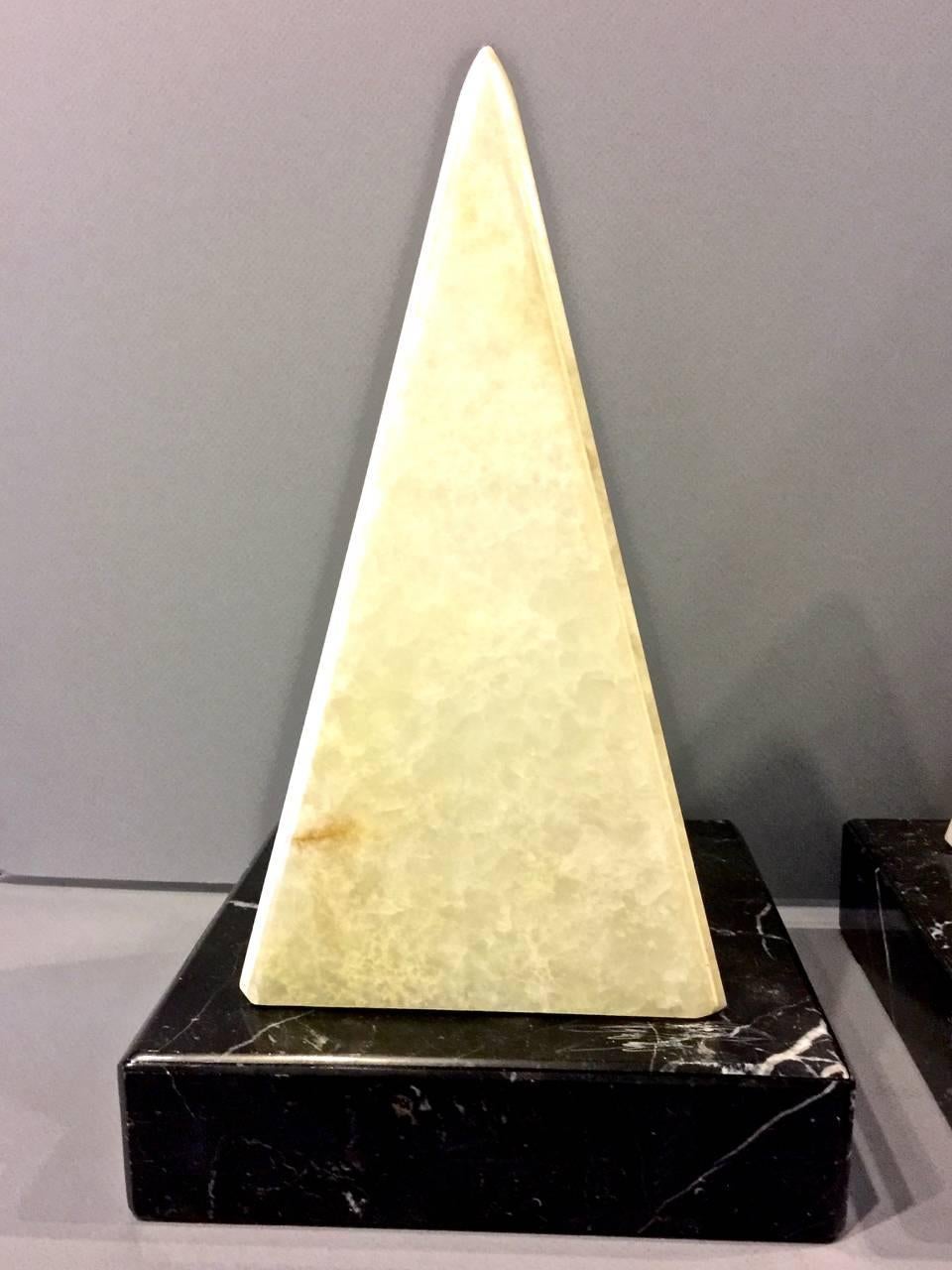 This is a very unusual pair of Mid-Century, circa 1960s alabaster and marble lamps in the form of obelisks. Unlit, the lamps appear to be simply obelisks; when lit, they become show stoppers.