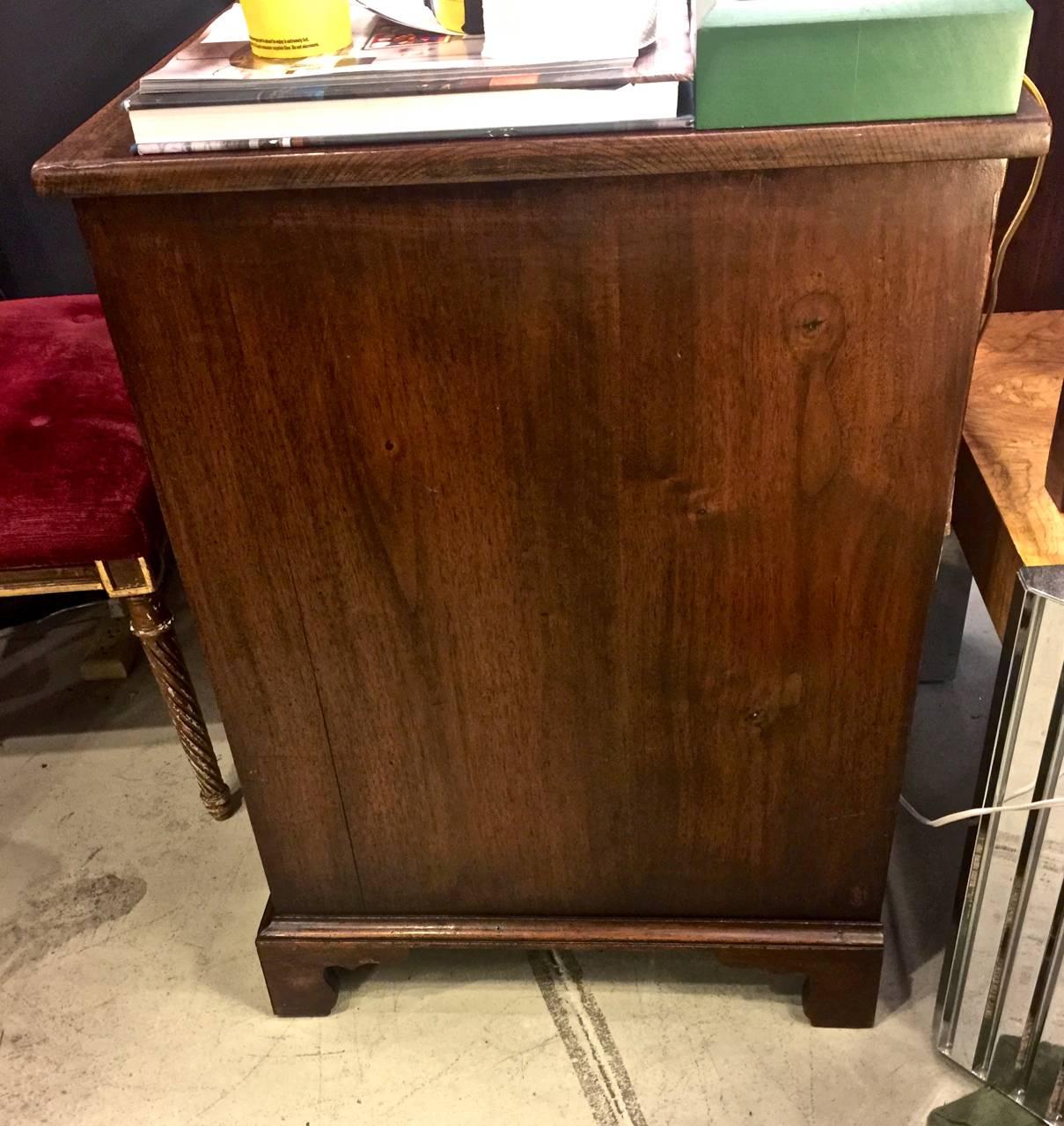 Beautiful feather banded walnut kneehole desk dating to first half of eighteenth century. Although the desk appears to be English, it is constructed with chamfered drawer bottoms and pine as a secondary wood, both indications of an American origin.