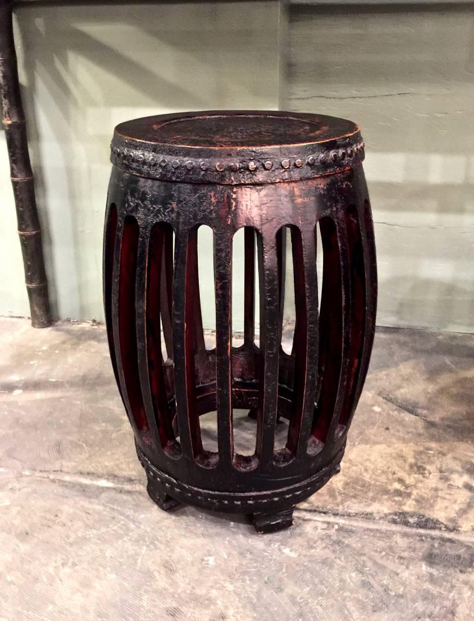 This is a highly decorative pair of early 20th century Chinese carved and lacquered wood garden stools. These stools are an uncommon form and have acquired a deep rich natural patina.