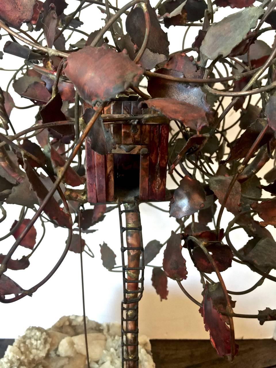 This is a large and fanciful Brutalist-inspired brass and copper sculpture of a child's imaginary play scene. The tree house, bicycle, swing and ladder and beautifully executed. The rock crystal geode fragment measures an impressive 11 in. x 8.5 in.