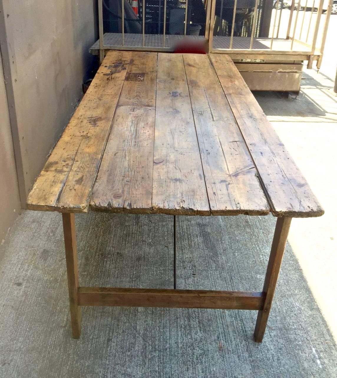 This is a n uncommon form of French harvest/farm table whose legs are braced with folding iron stretchers which allow the table to fold flat--great for shipping. The original waxed pine surface is in excellent patinated condition and has just had a