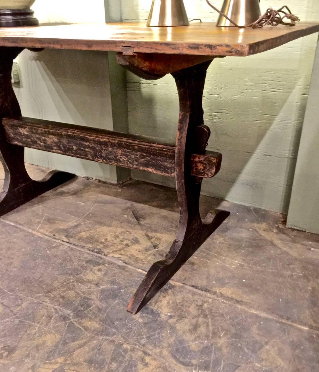 The is an iconic late 18th-early 19th century Swedish trestle table. The table is in overall very good to excellent condition. It retains much of its black painted surface. The two board top and deep natural patina is an indication of its age. The