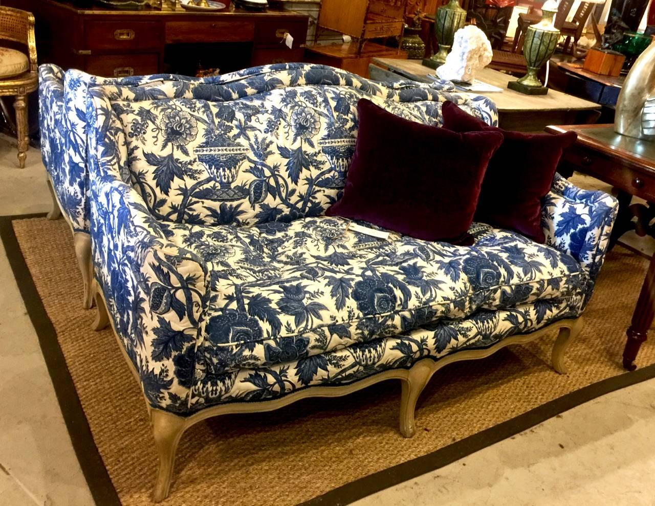 This is a stunning pair of circa 1970-80 Louis XV-Style small sofas or settees that are upholstered in an exceptional vintage Pierre Deux attributed cobalt toile. The toile is a very complex and detailed cobalt blue (most probably hand stamped)