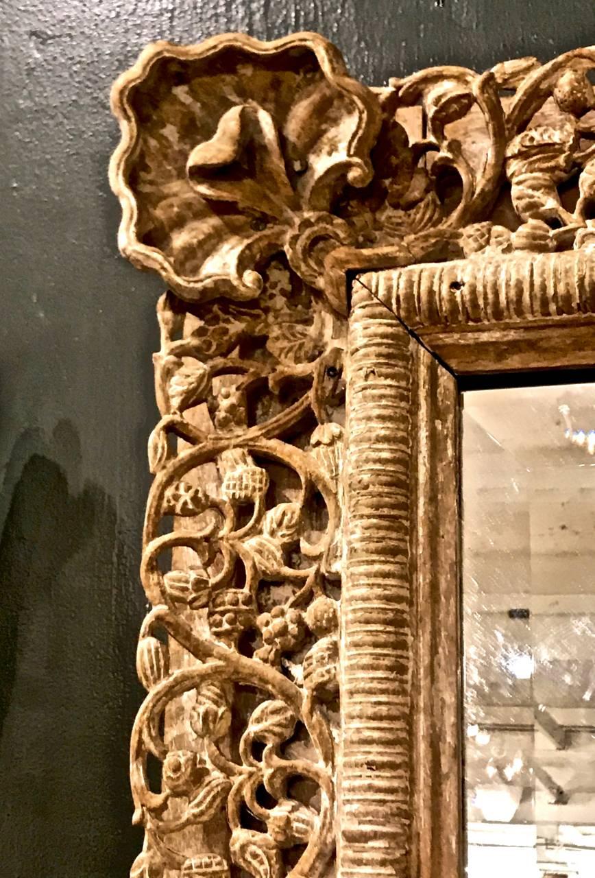 This is a large highly carved Anglo-Indian Mirror that dates to the later part of the nineteen century (perhaps, early 20th). The intricately carved foliate frame is in remarkably good condition with no observed restorations or losses--there is