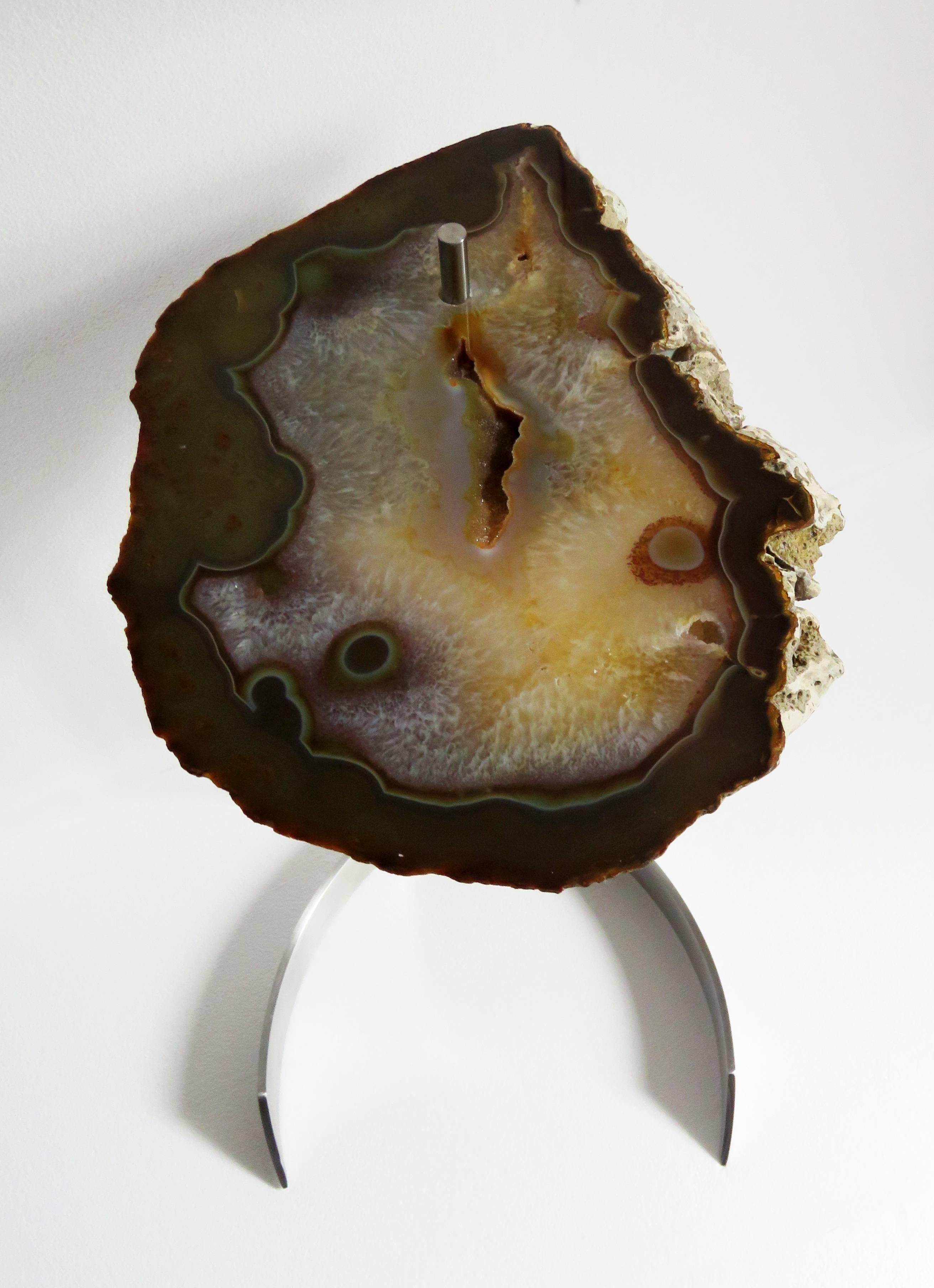 This agate slab is from Brazil.
Agates are formed in rounded nodules, which are sliced open to bring out the internal pattern hidden in the stone. Their formation is commonly from depositions of layers of silica filling voids in volcanic vesicles