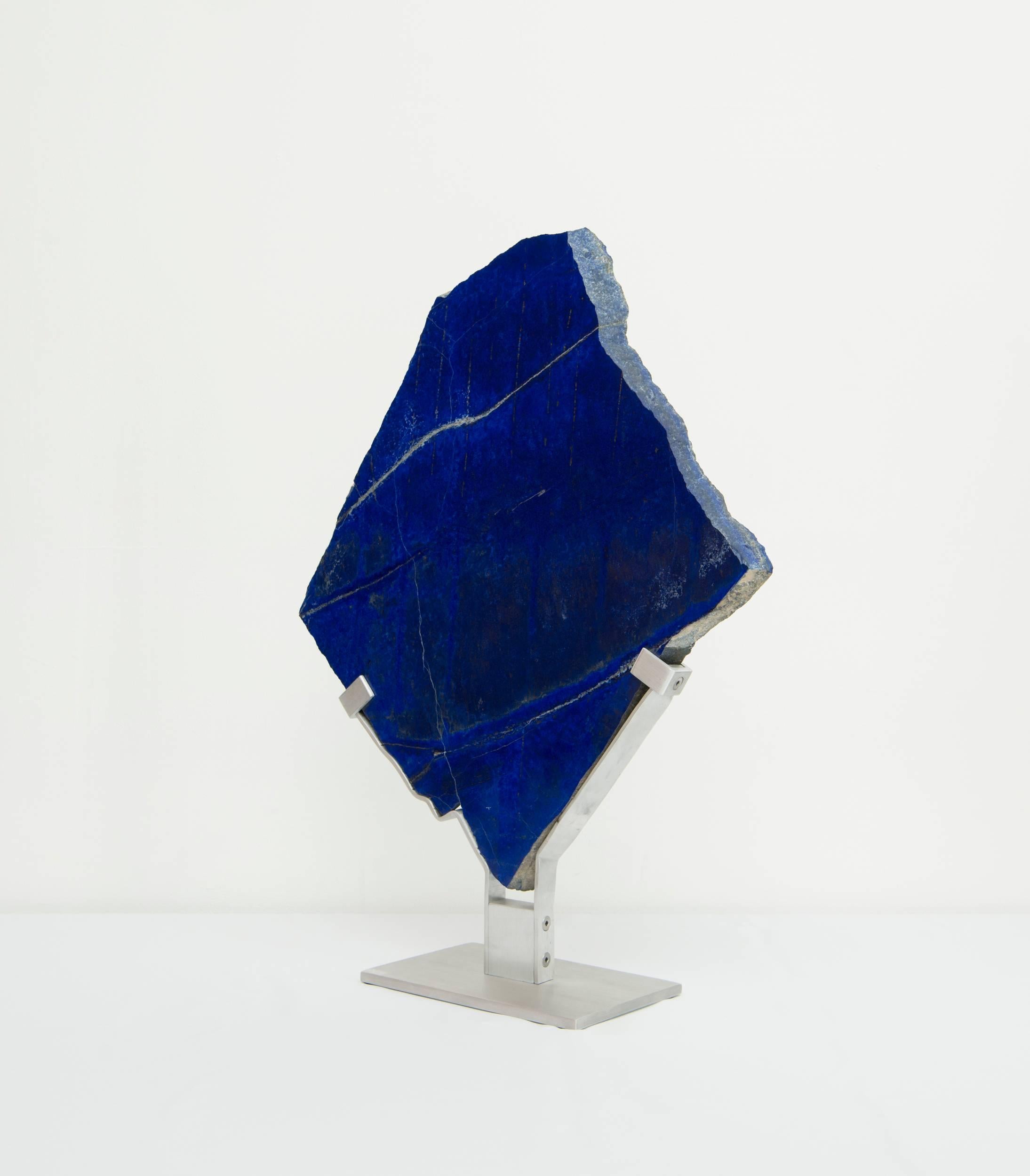 Lapis Lazuli is a deep blue metamorphic rock used as a semi-precious stone that has been prized since antiquity for its intense color. 
It is a combination of lazurite, main constituent, white calcite and pyrite.
The lapis sculpture is 19” x 1” x