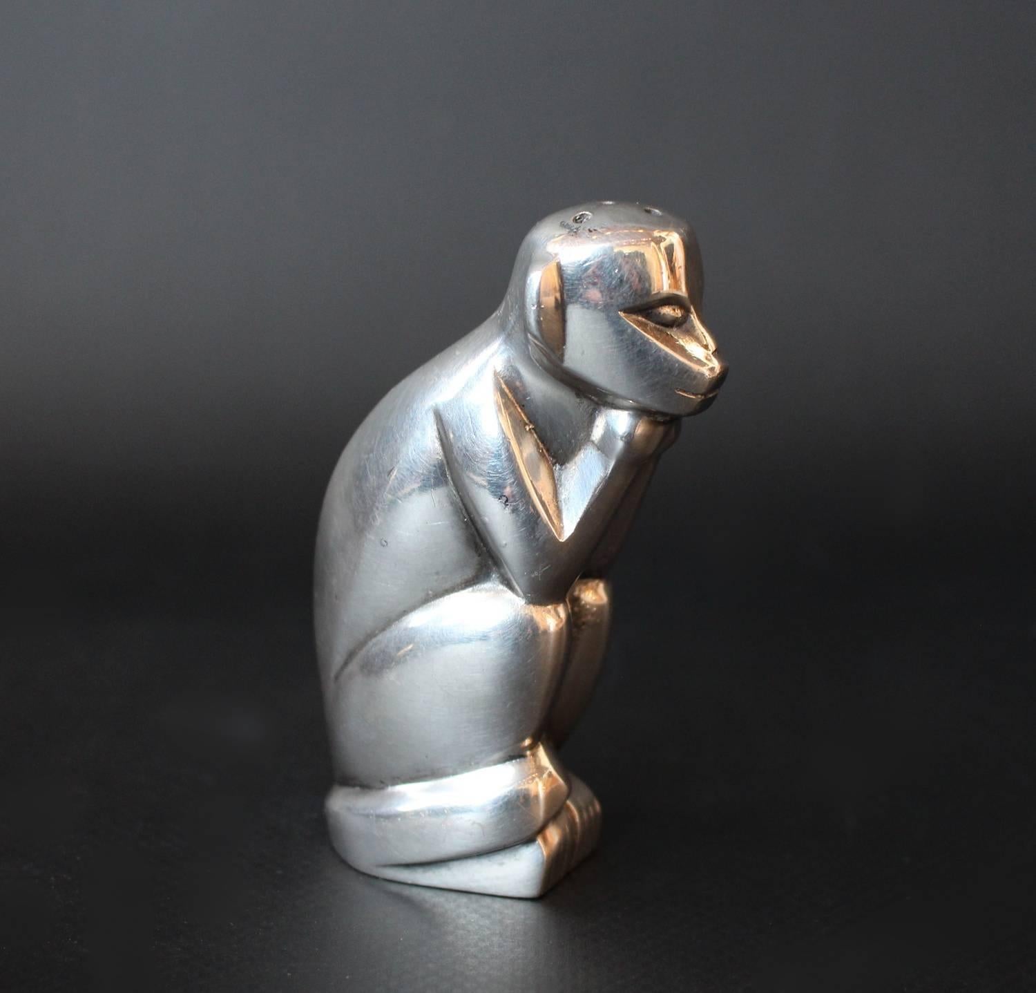 An Art Deco, silver plated pepper shaker in the form of a stylized monkey resting his chin on his hands. Designed by Edouard Marcel Sandoz for Gallia (Maison Christofle). Stamped O. Gallia to side.
  