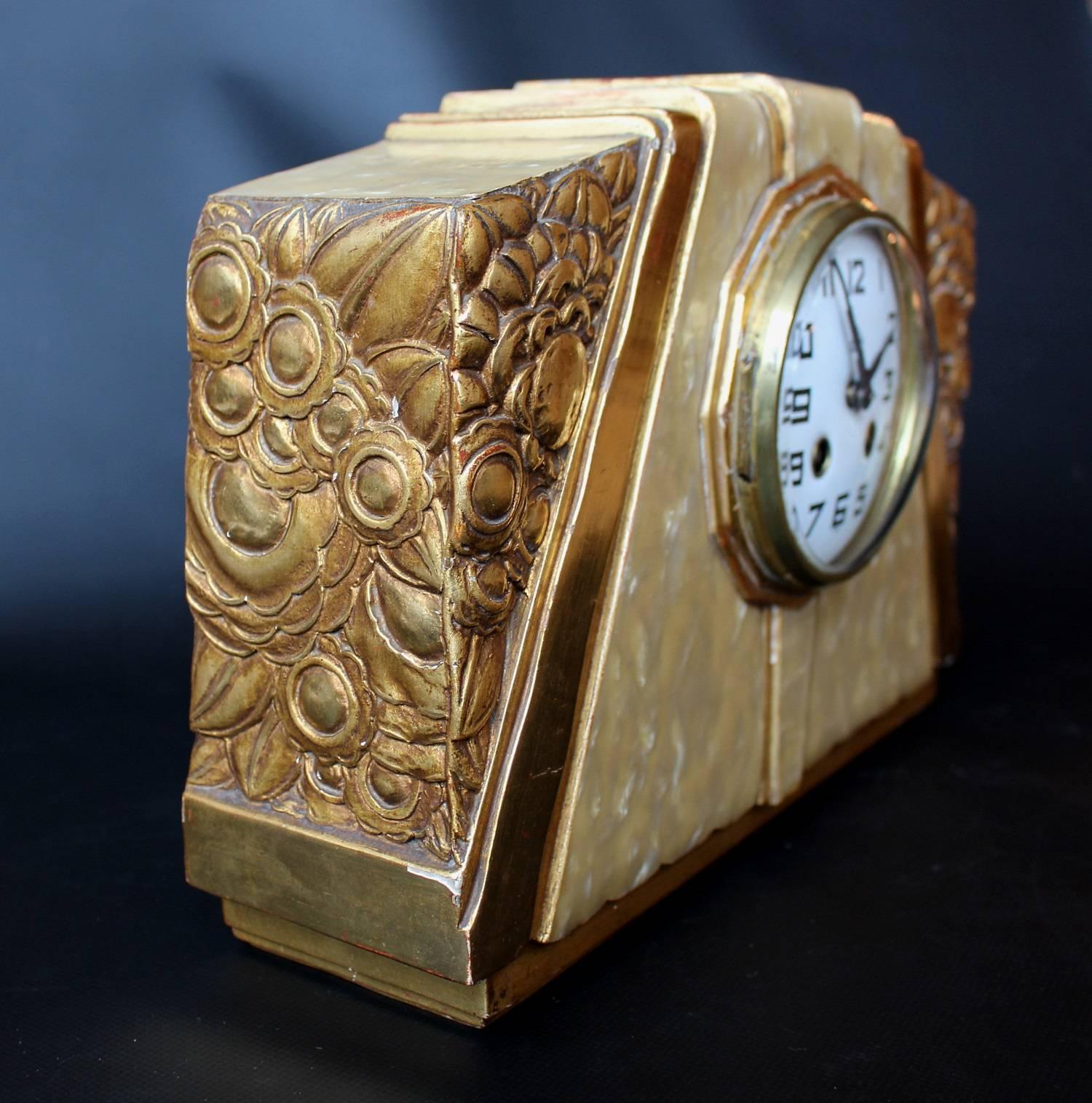 An Art Deco mantel clock attributed to Süe et Mare - Louis Süe (1875-1968) and André Mare (1887-1932). Bakelite and giltwood carved with stylized flowers. 8 day movement.

 