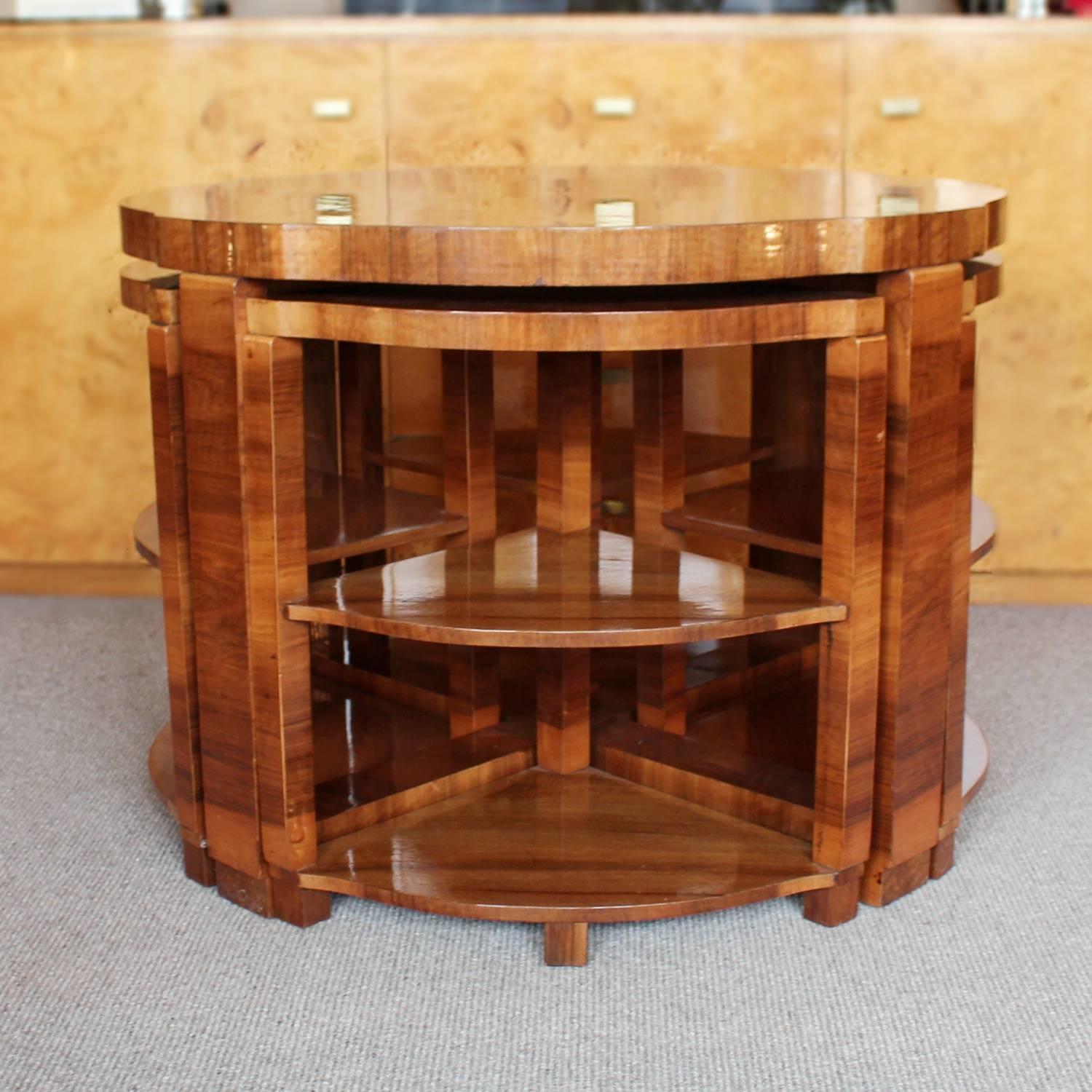 An Art Deco nest of tables. Shaped, circular table with cross footed base and four integral, shelved side tables. Figured walnut throughout.

Measures: H 54 cm, D 76 cm, Side tables H 49 cm, W 46 cm, D 32 cm.

  