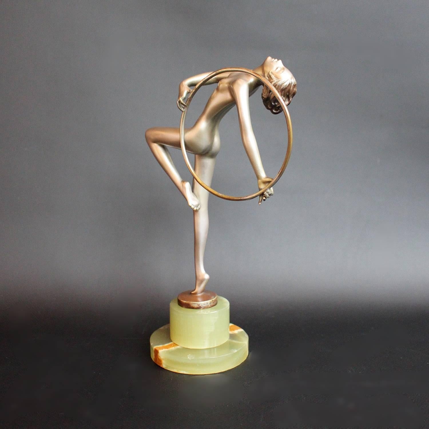 Dancer with Hoop, a cold painted bronze sculpture by Josef Lorenzl (1892-1950). A young lady stands on tiptoe in stylised pose, holding a hoop. Signed Lorenzl to bronze.


