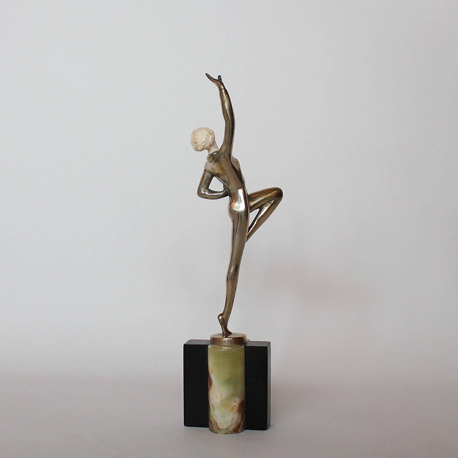 An Art Deco, silvered bronze and ivory figure of a dancer in stylised pose. Set over a bi-colored plinth of black marble and green onyx. Signed Lorenzl to bronze.

Artist: Josef Lorenzl (1892-1950).

