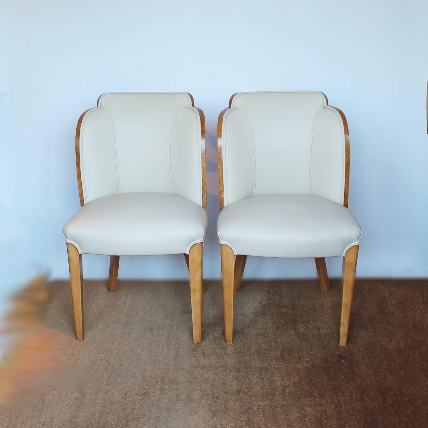 A pair of cloud form, Art Deco chairs by Harry & Lou Epstein. Figured walnut backs. Upholstered in cream leather.

Dimensions: H 87 cm, W 54 cm, D 50 cm, seat H 48 cm, seat D 42 cm.

