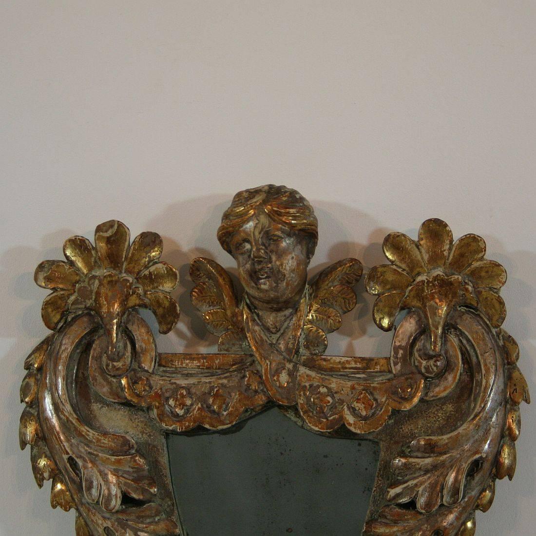 Unique and stunning Baroque mirror with a beautiful angel-head and traces of its original gilding and silver, Italy, circa 1700-1750
Weathered, small losses and old repairs.
