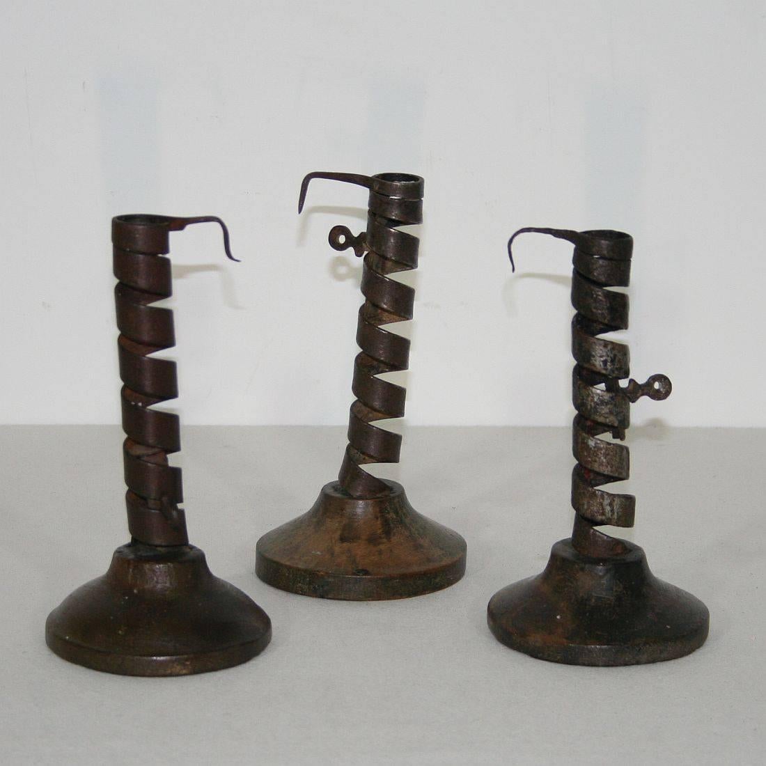 Great collection of three late 18th century French adjustable spiral candlesticks, all on their original simple domed fruit-wood bases, hand-wrought iron, with wonderful delicate detail to the handles. Rat de cave candleholders from Normandy,