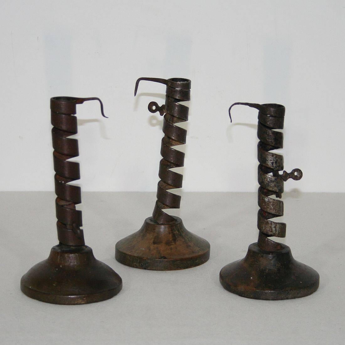 Great collection of three late 18th century French adjustable spiral candlesticks, all on their original simple domed fruit-wood bases, hand-wrought iron, with wonderful delicate detail to the handles. Rat de cave candleholders from Normandy,