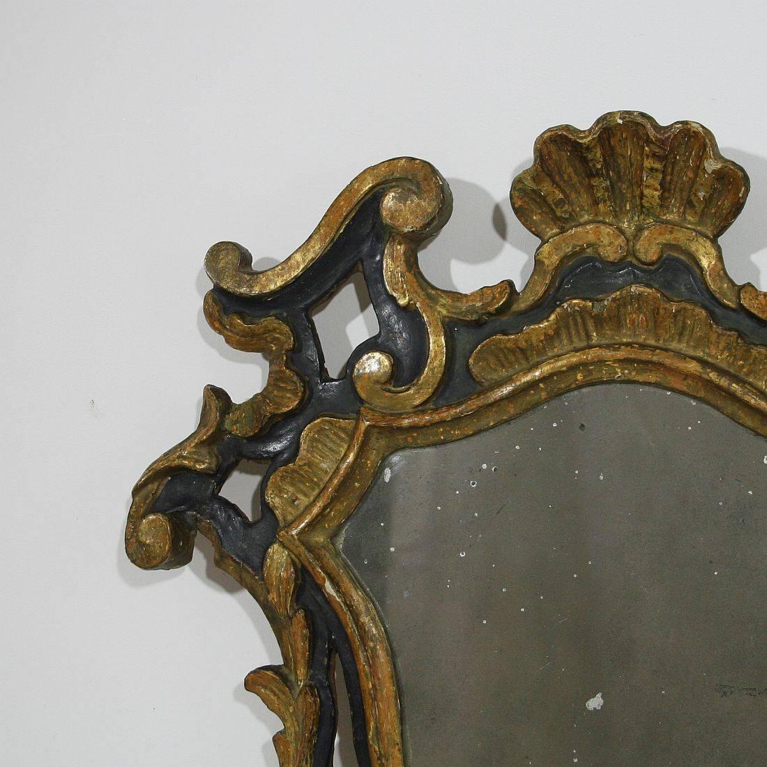 Beautiful carved wood mirror with its gilding and blue color
Italy, circa 1700-1750
Weathered, old repairs and small losses.