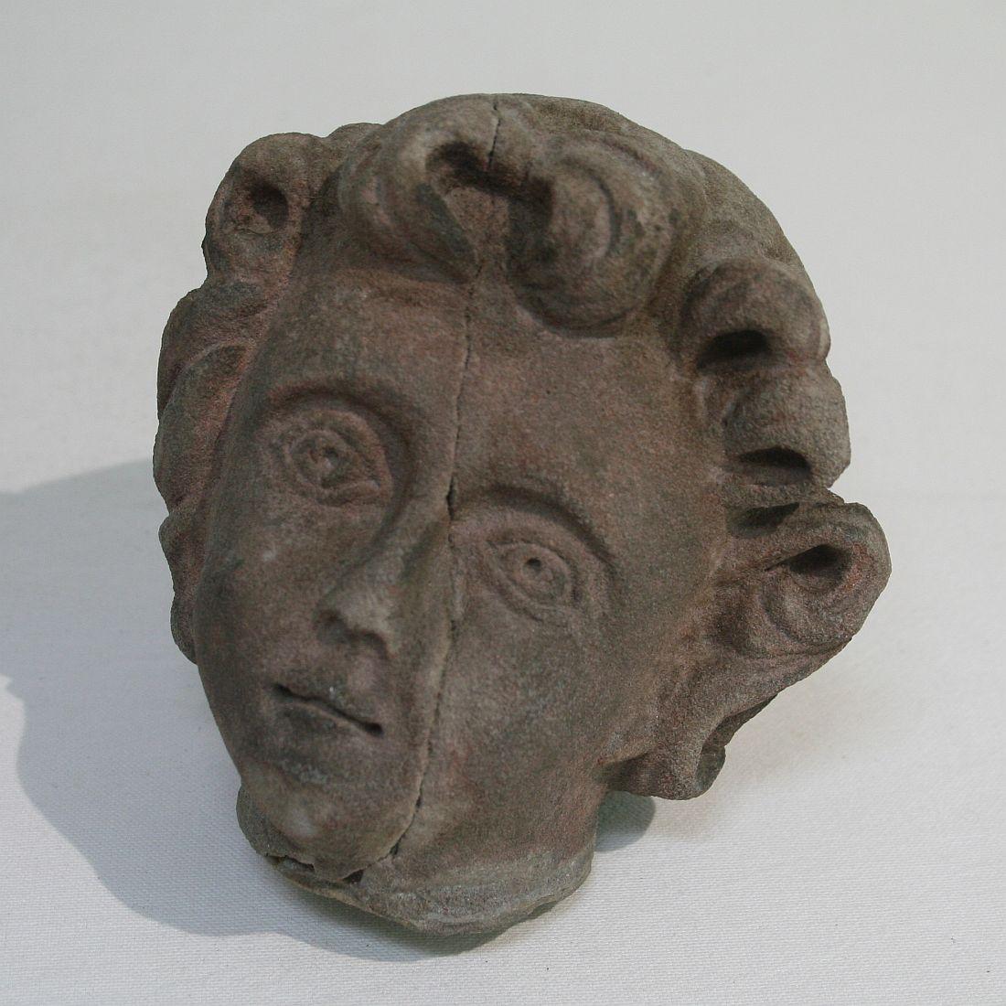 Nice sandstone angel head, France, circa 1750. Weathered, losses and old repairs. Once broken.