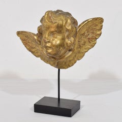 Ángel querubín italiano antiguo de madera dorada sobre peana, hacia 1650-1750