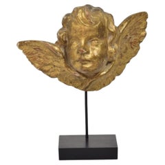 Ángel querubín italiano antiguo de madera dorada sobre peana, hacia 1650-1750