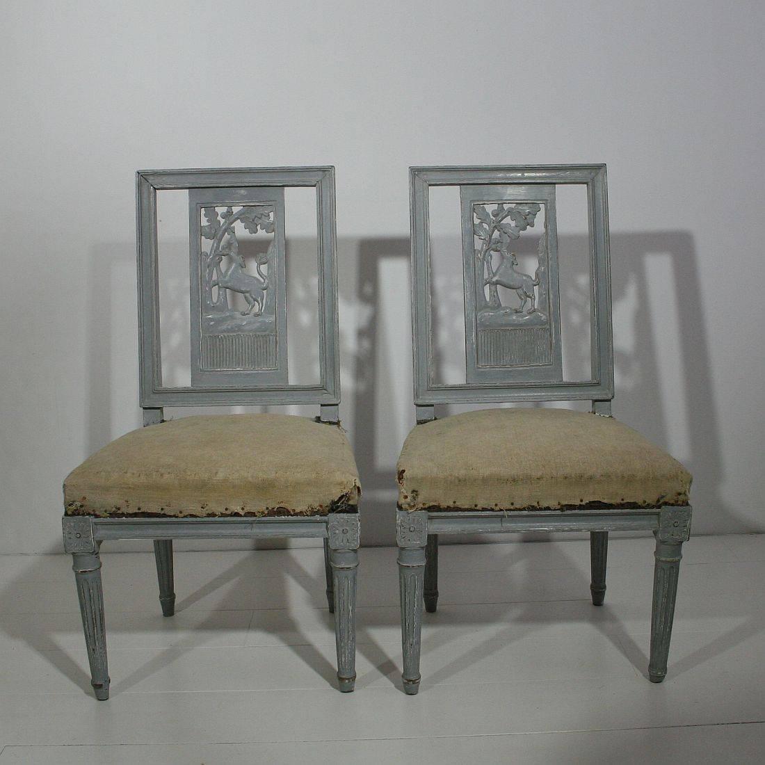 Stunning pair of side chairs with great colour and unique hand-carved decor. Original period pieces with colour of later date, France, circa 1760. Weathered, small losses.