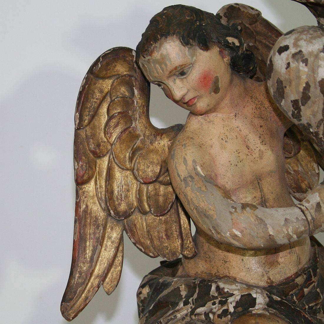 Stunning period piece. Baroque angel with its original color holding a torchère. Very beautiful piece.
Italy, circa 1750. Weathered, old repairs and small losses.
Measurement is with the wooden base.
More pictures are available on request.