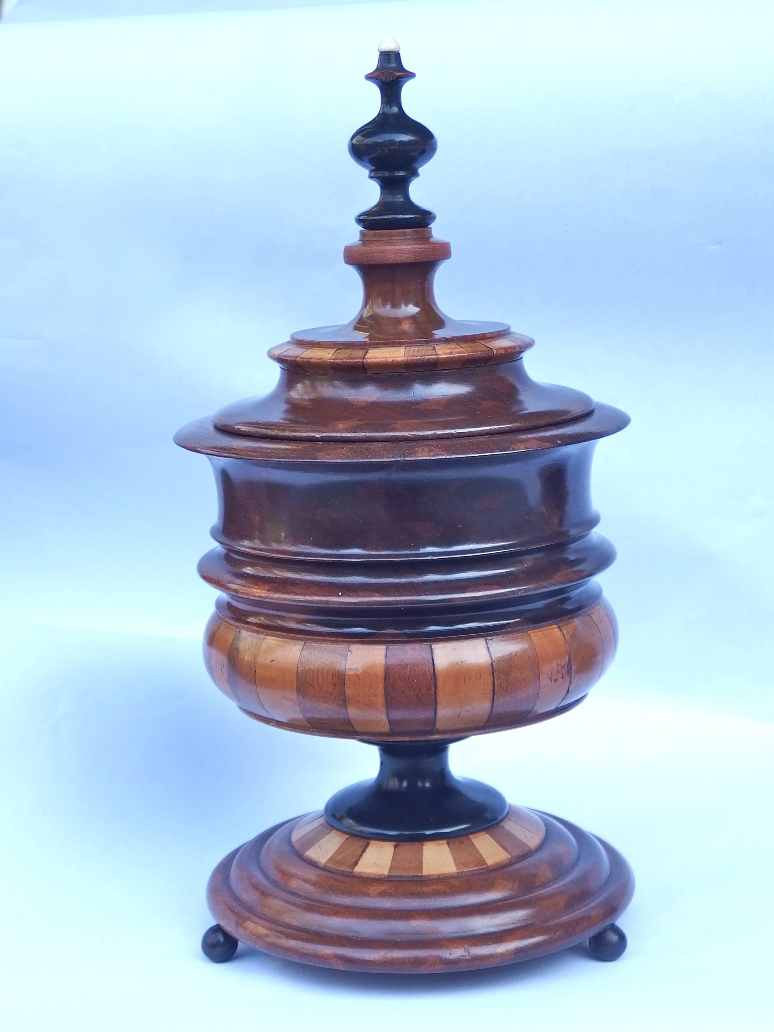 Collection of Dutch treen tobacco jars. These jars are made of turned mahogany and segmented with several types of precious wood. The left one and middle one have an ivory top and the right one a bone top. The left tobacco jar has a tiny bit missing