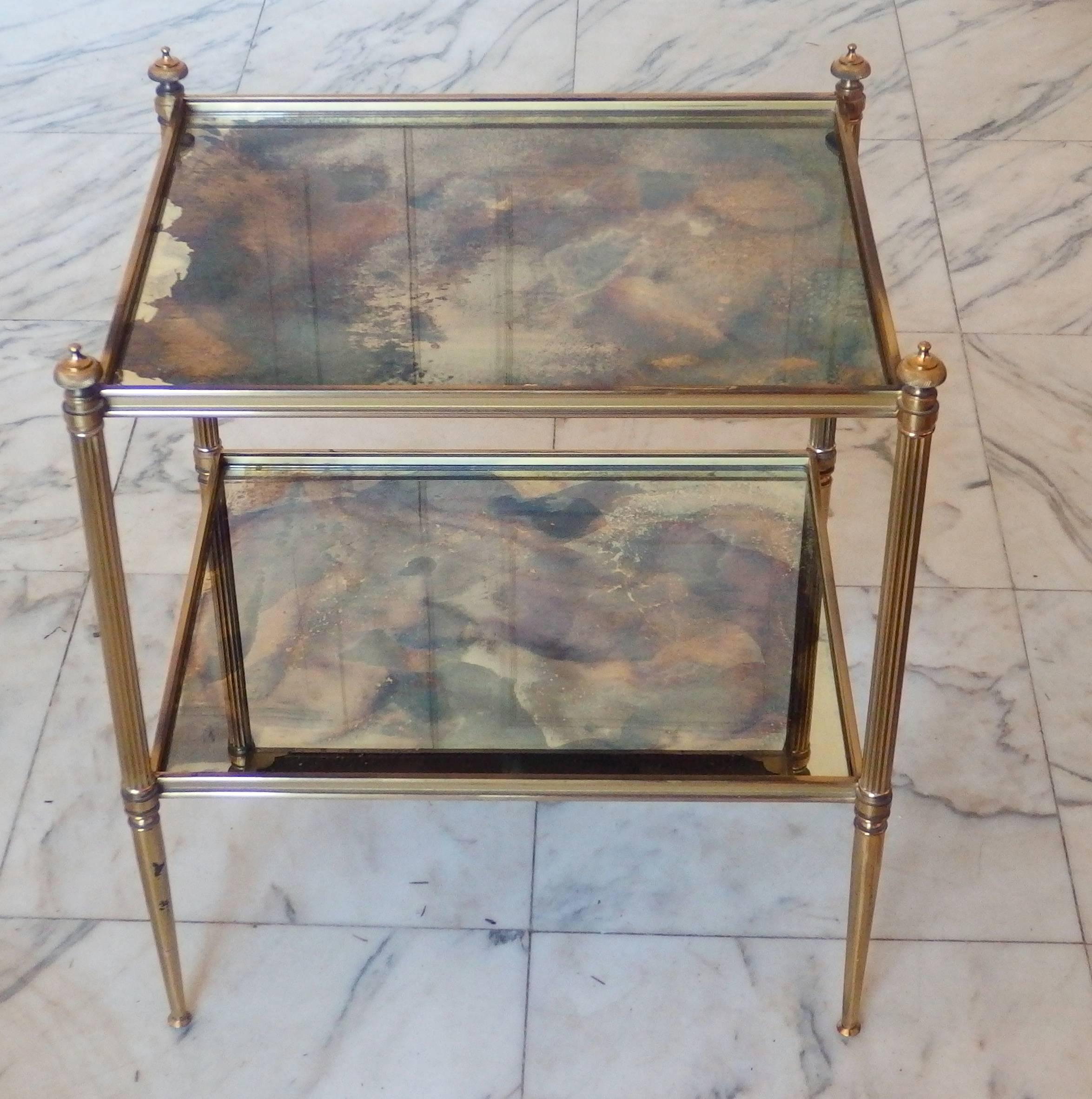 Pair of two-tier brass end tables with eglomised mirror glass.
  