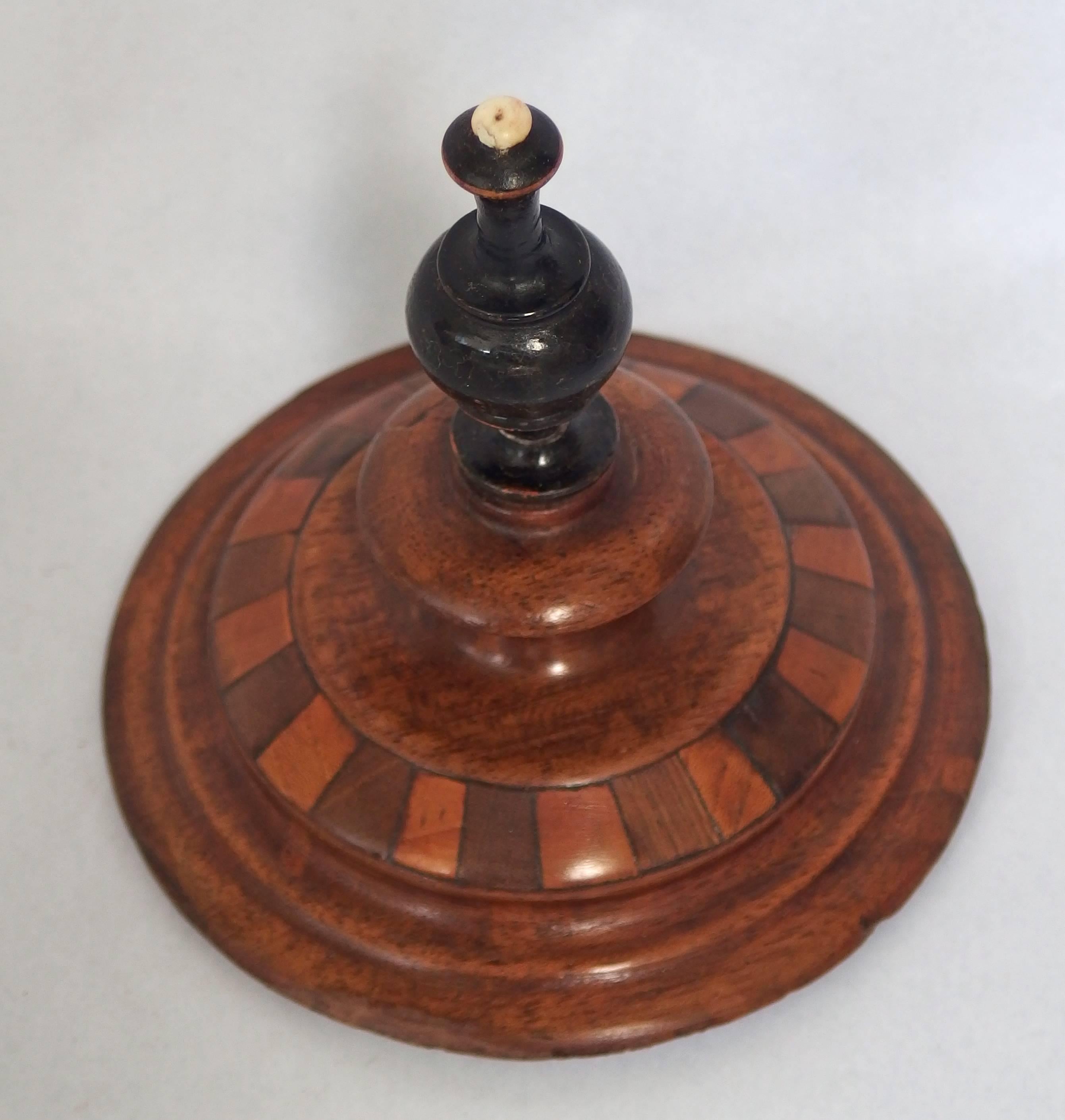 Dutch treen tobacco jar from the 19th century. This jar is made of turned mahogany, partly segmented with several types of precious wood and has an ivory top.