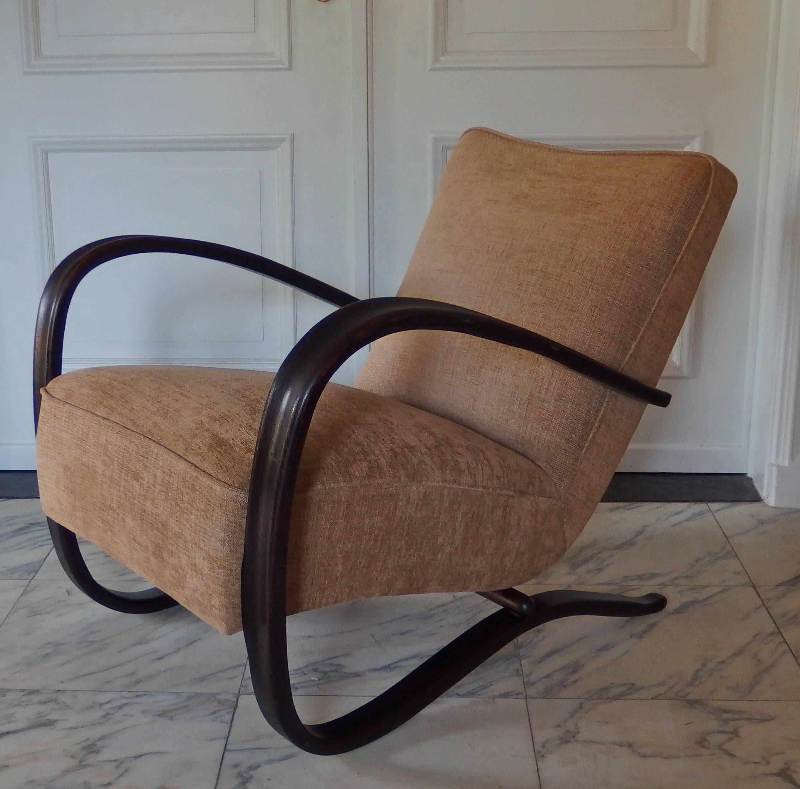 Pair of iconic Art Deco dark brown beechwood lounge chairs designed by Jindrich Halabala (Czech Republic, circa 1930) and made by Thonet. These chairs are newly restored and reupholstered with a biscuit colored chenille.