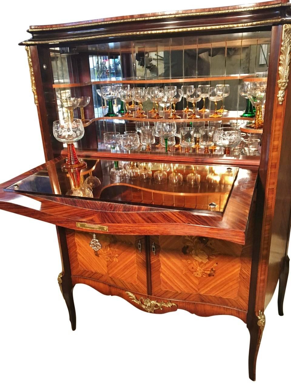 It's party time! Fabulous French tulip wood cocktail cabinet from the 1930s fully equipped with attractive stemmed glasses. well maintained by former owners, this cocktail cabinet is offered in excellent showroom condition.

This delightful cabinet,
