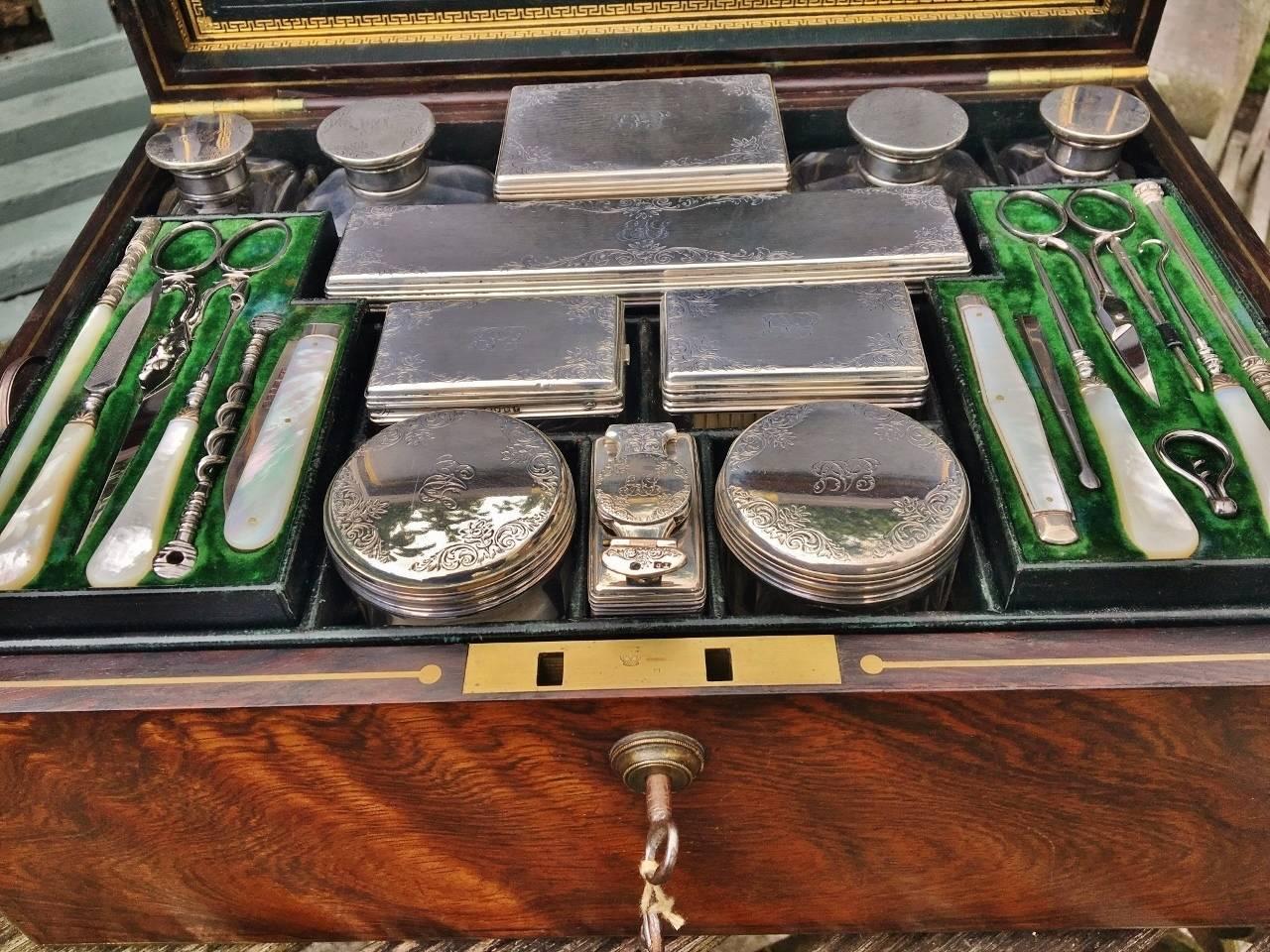 Attractive early 19th century rosewood Vanity case / travelling case, enclosing fabulous silver topped bottles, jars for creams, cologne, powders and manicure sets. English, circa 1840s. This is an important Vanity case with a London maker, full of