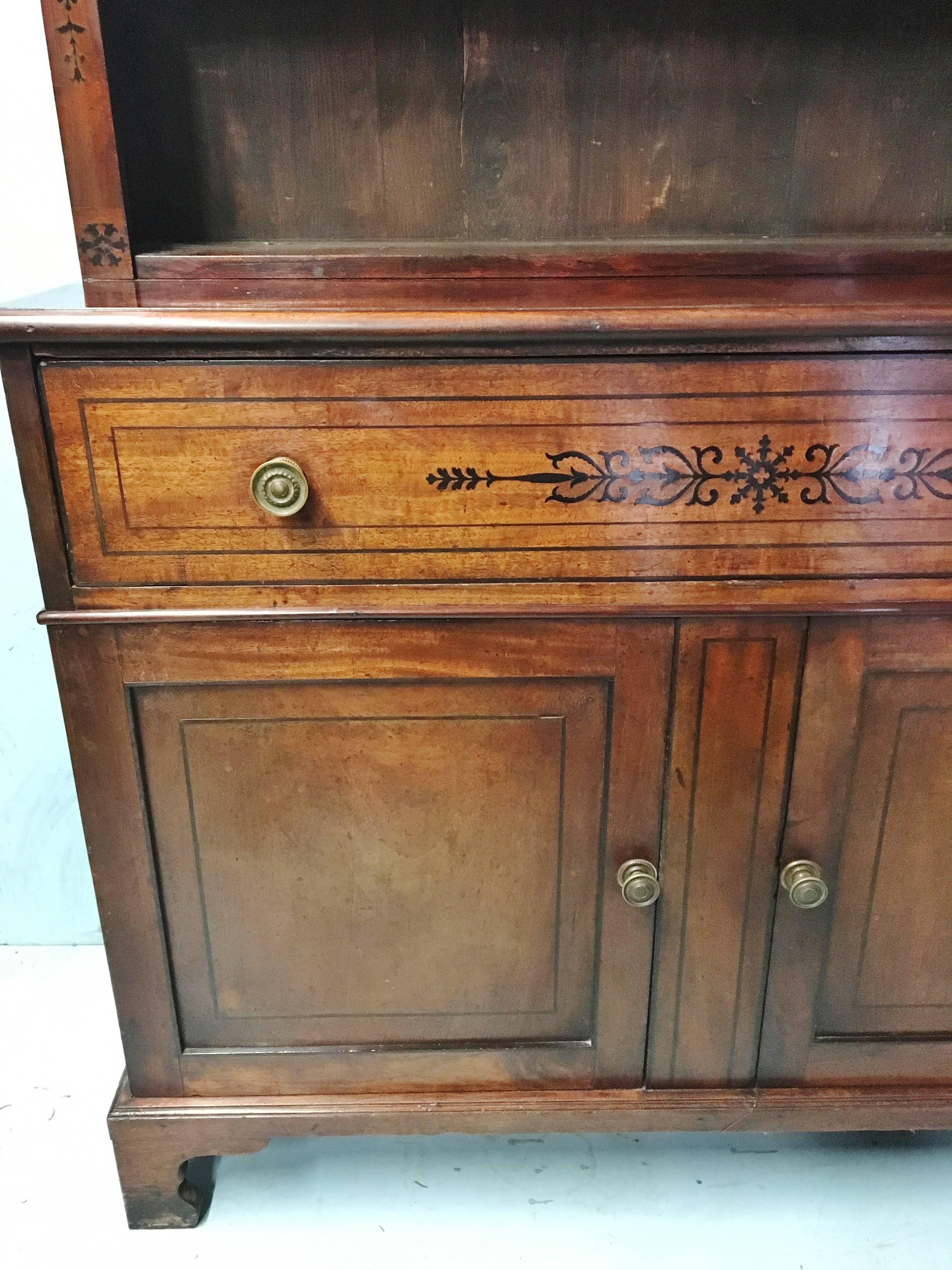 A good early 19th century two section mahogany dresser, sideboard, with inlaid ebony decoration. Standing on bracket feet with two doors below one large central drawer, the finish is excellent and retains a rich antique patination.

There are two