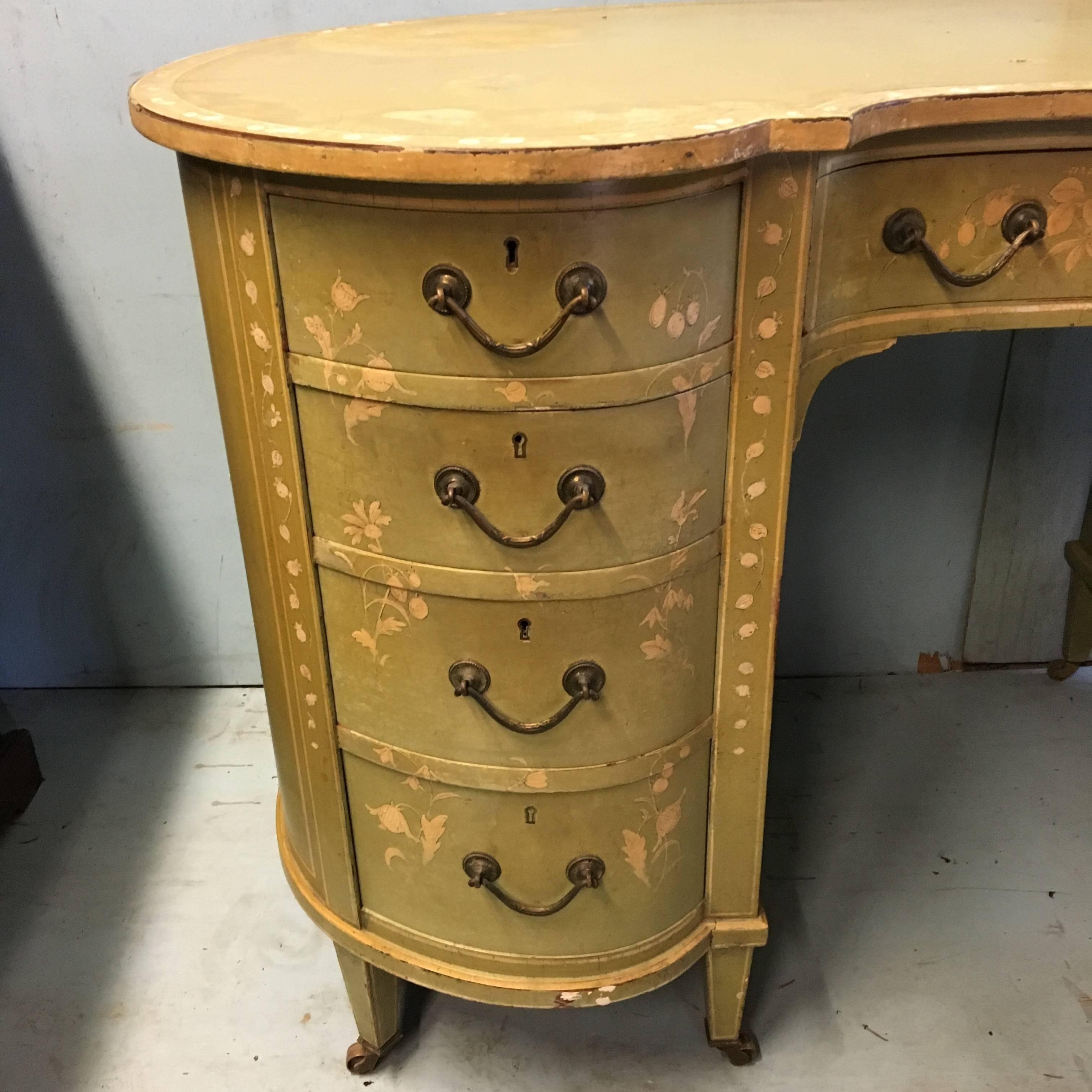 Very pretty and decorative early 20th century ladies writing desk. 
Dating to about circa 1915, this delightful desk has hand-painted floral designs onto a pale green background. Standing on eight tapered and decorated legs with original brass