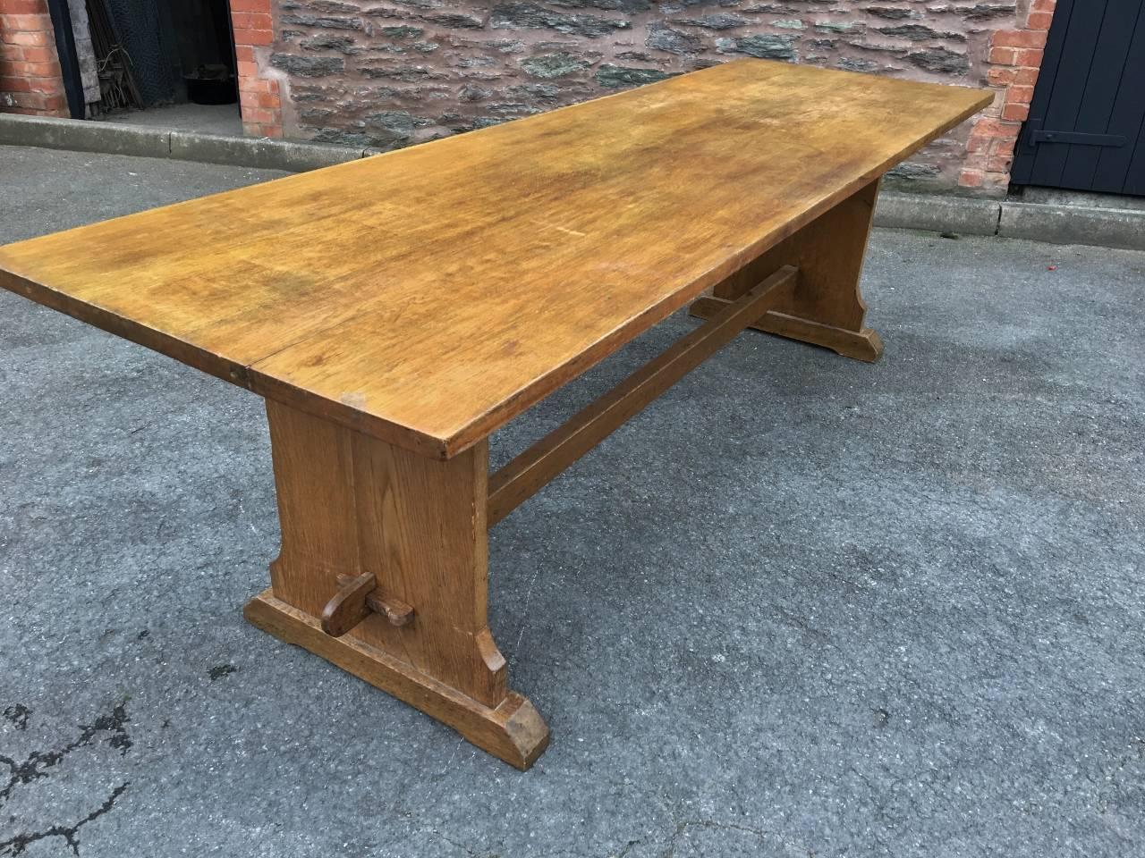 Attractive 1920s oak dining table in excellent condition. Of the Arts and Crafts period, this delightful table is a comfortable eight to ten seater. The top bolts to the base and the base is secured with wooden pegs. Lovely family size table.

The