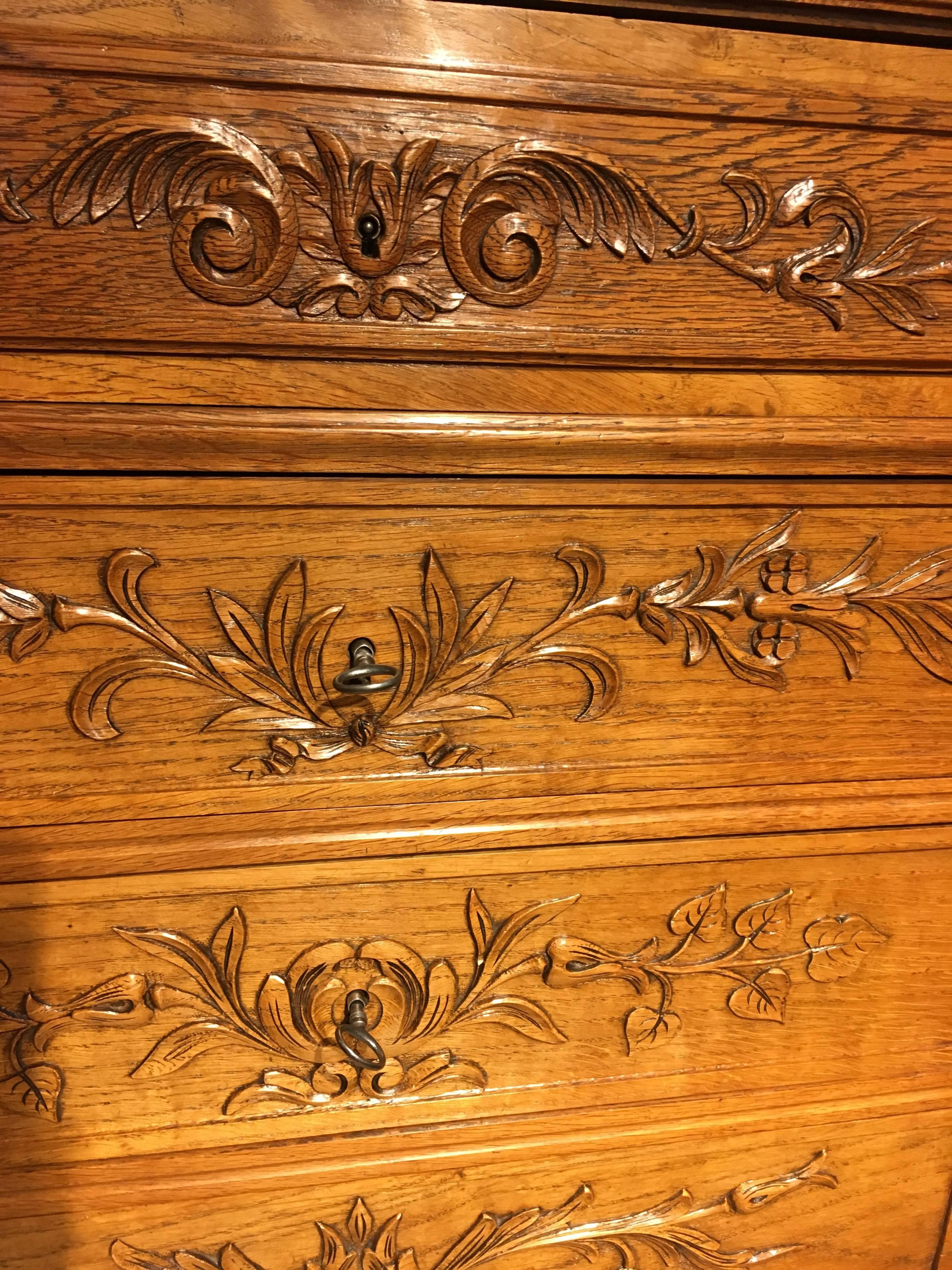 Very nice quality late 19th century golden oak tall chest of drawers 

this piece is French and dates to around the 1890s 

Having six drawers each with working lock and key, the carving on each drawer front is different to the others 

This